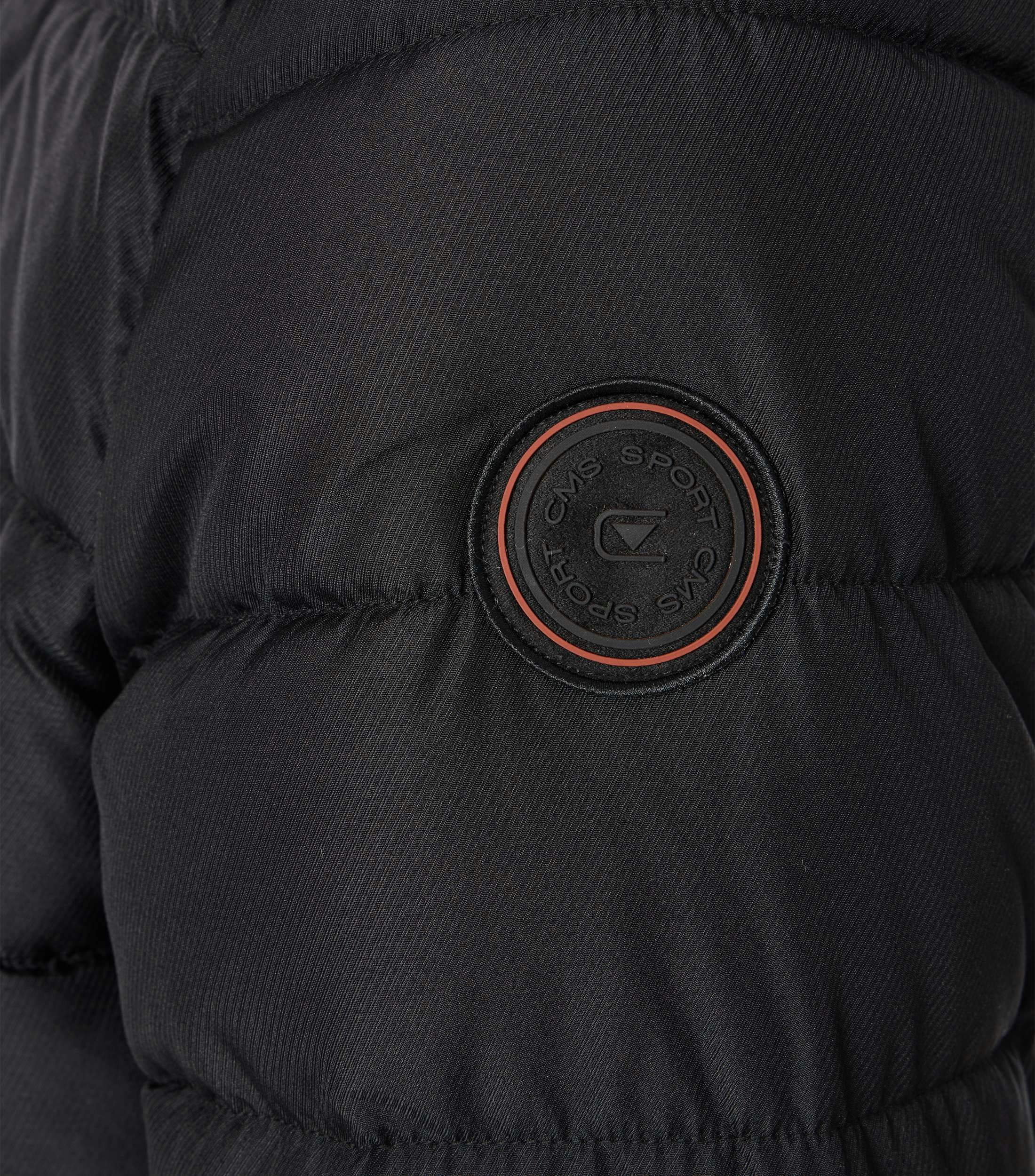 Das Model trägt eine Jacke im uni Muster in der Farbe Schwarz