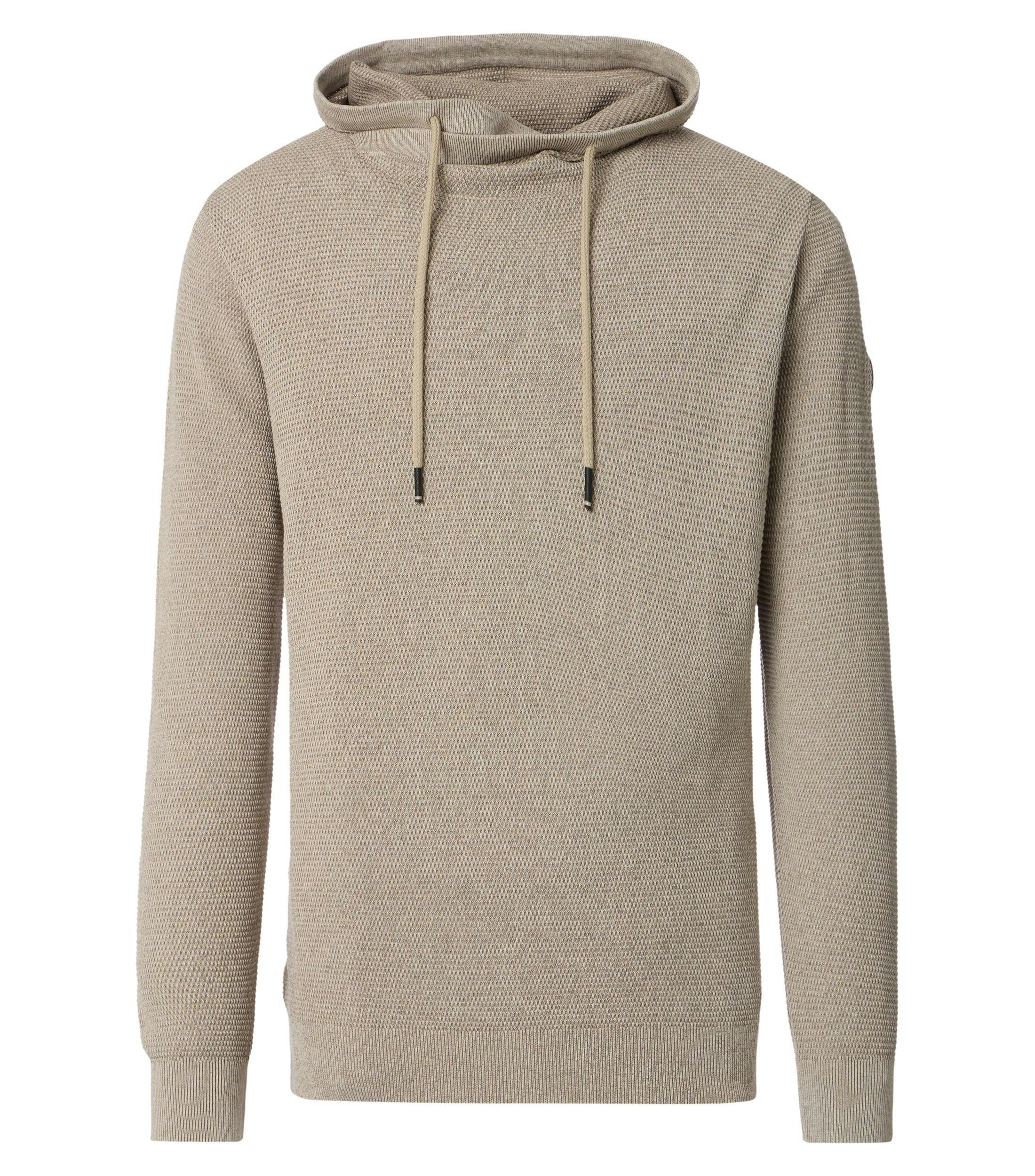 Das Model trägt ein Pullover im uni Muster in der Farbe Beige