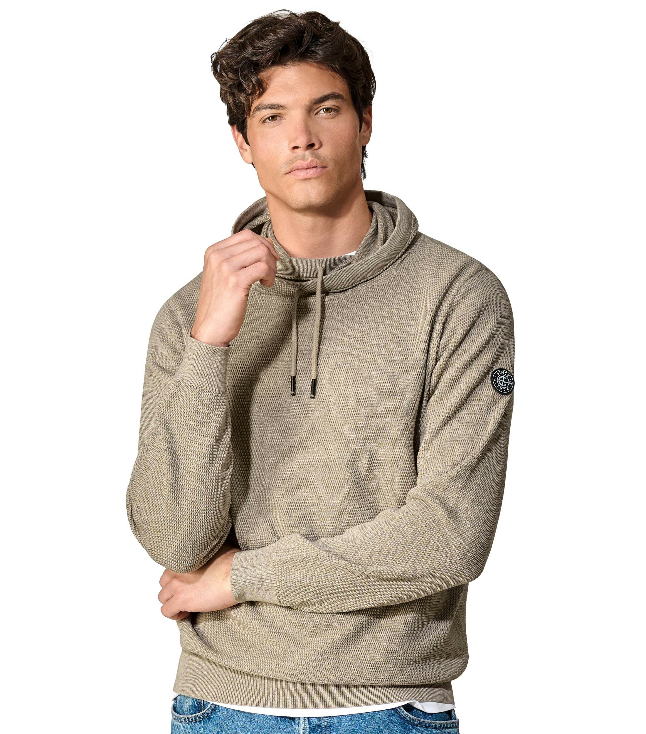 Das Model trägt ein Pullover im uni Muster in der Farbe Beige