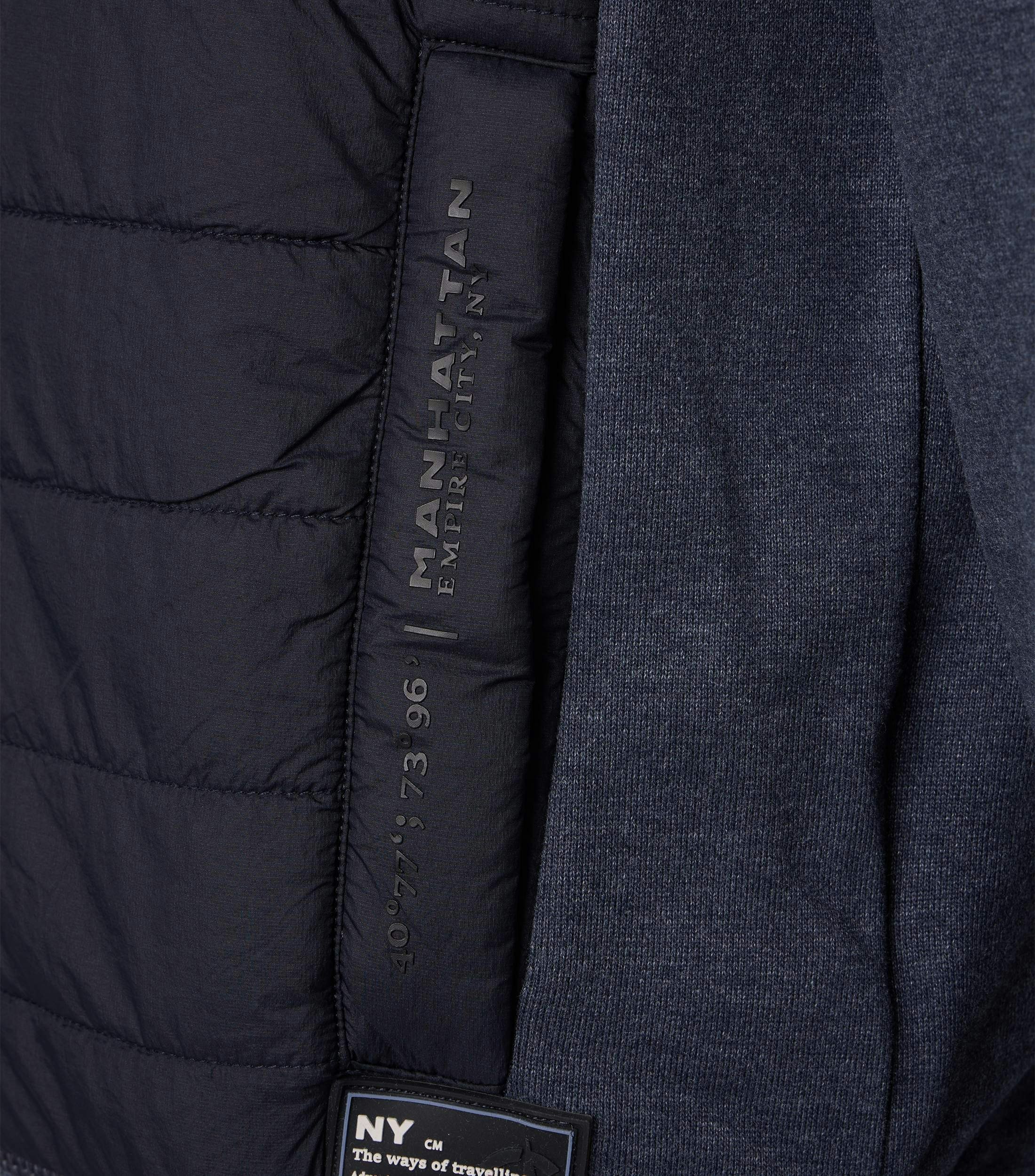 Das Model trägt eine Sweatjacke im uni Muster in der Farbe Blau