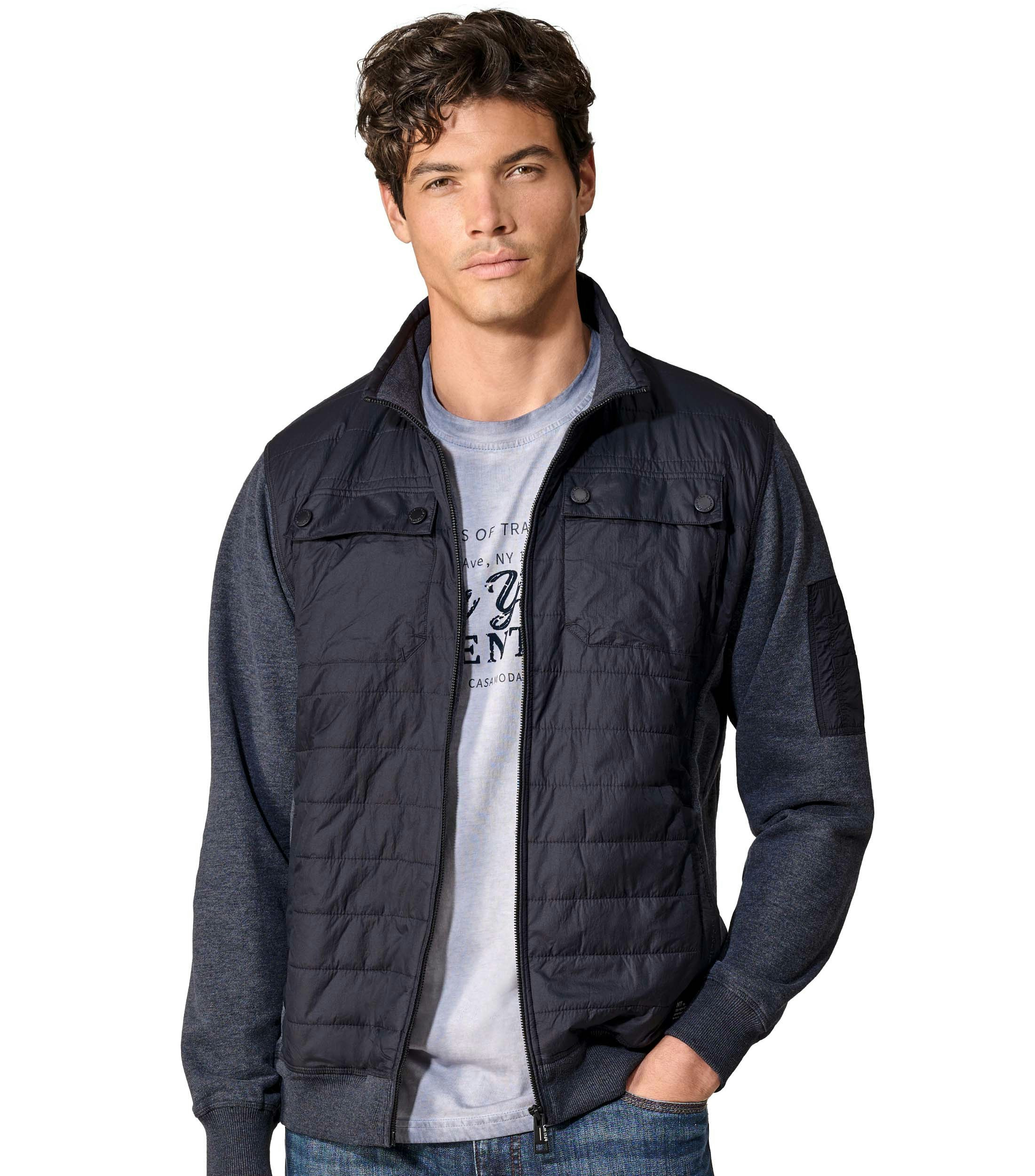 Das Model trägt eine Sweatjacke im uni Muster in der Farbe Blau