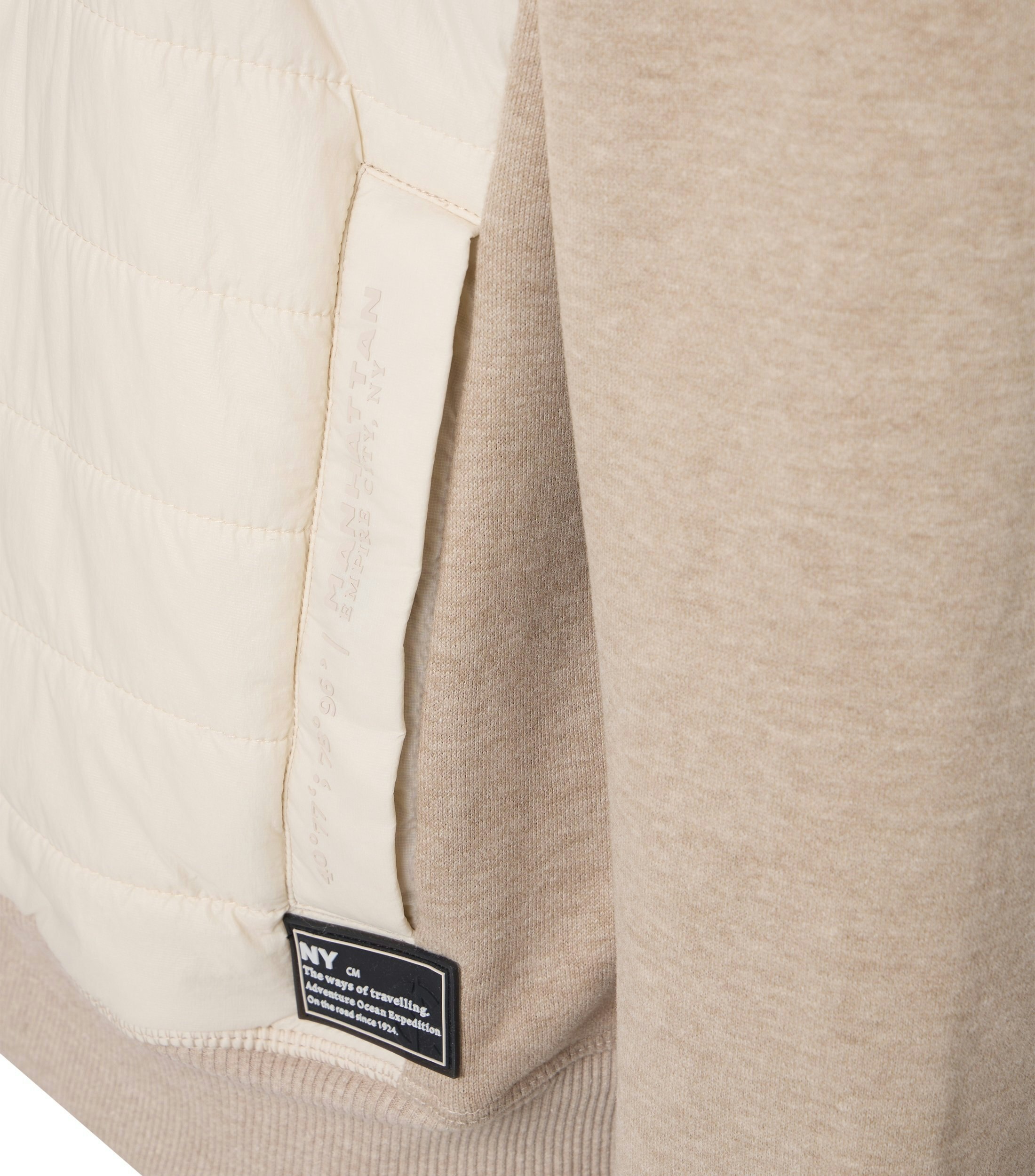 Das Model trägt eine Sweatjacke im uni Muster in der Farbe Beige