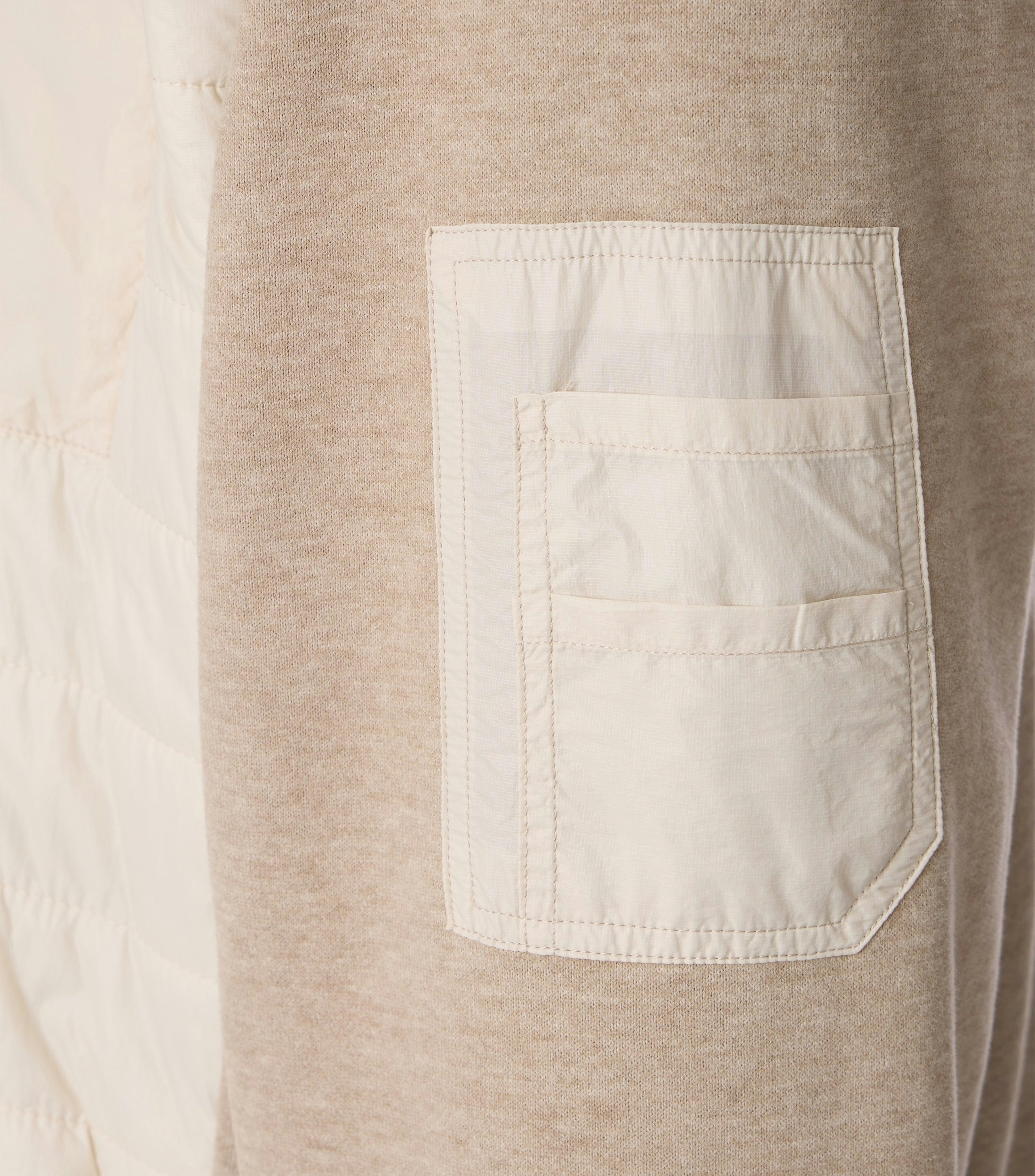 Das Model trägt eine Sweatjacke im uni Muster in der Farbe Beige