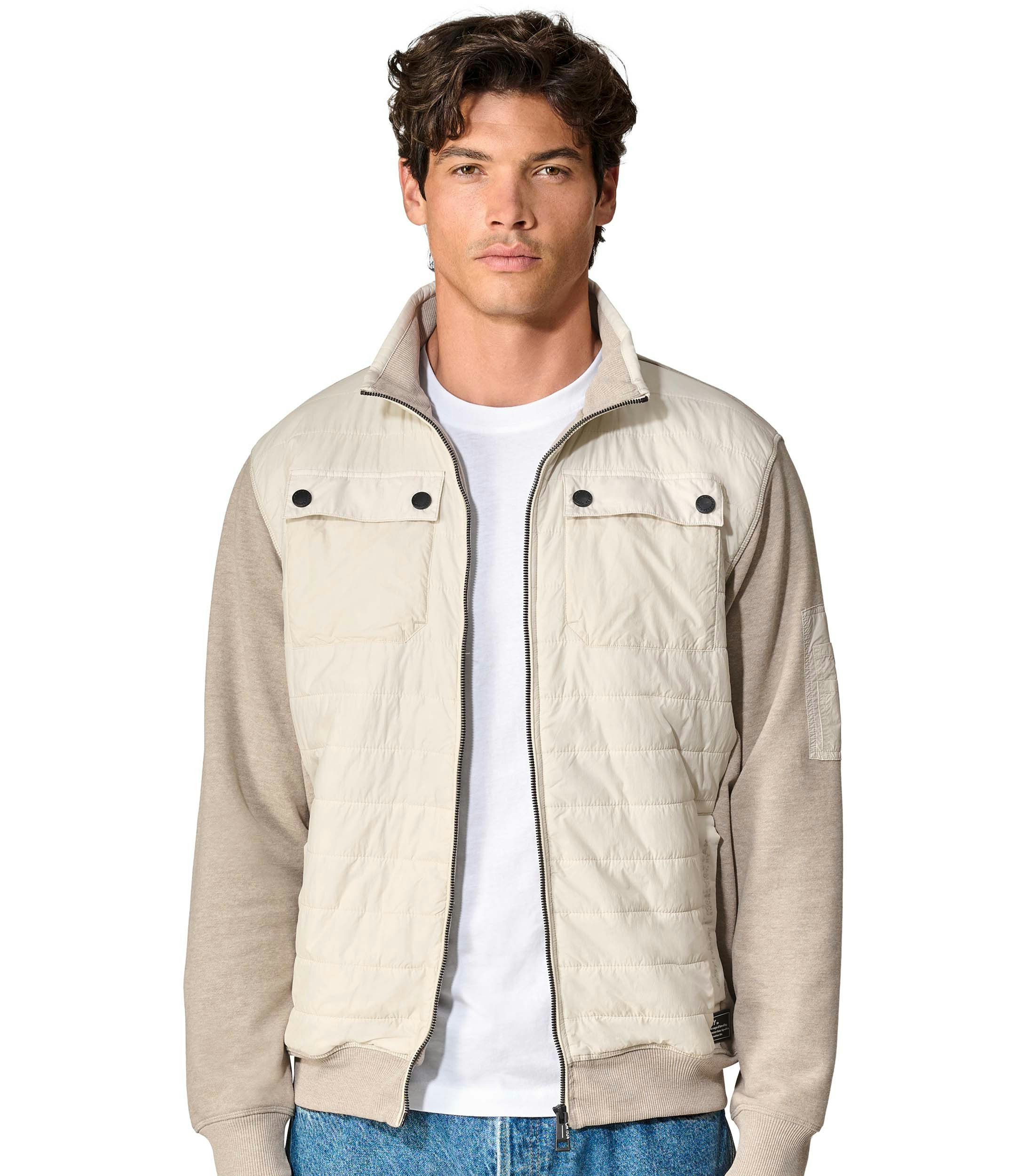 Das Model trägt eine Sweatjacke im uni Muster in der Farbe Beige