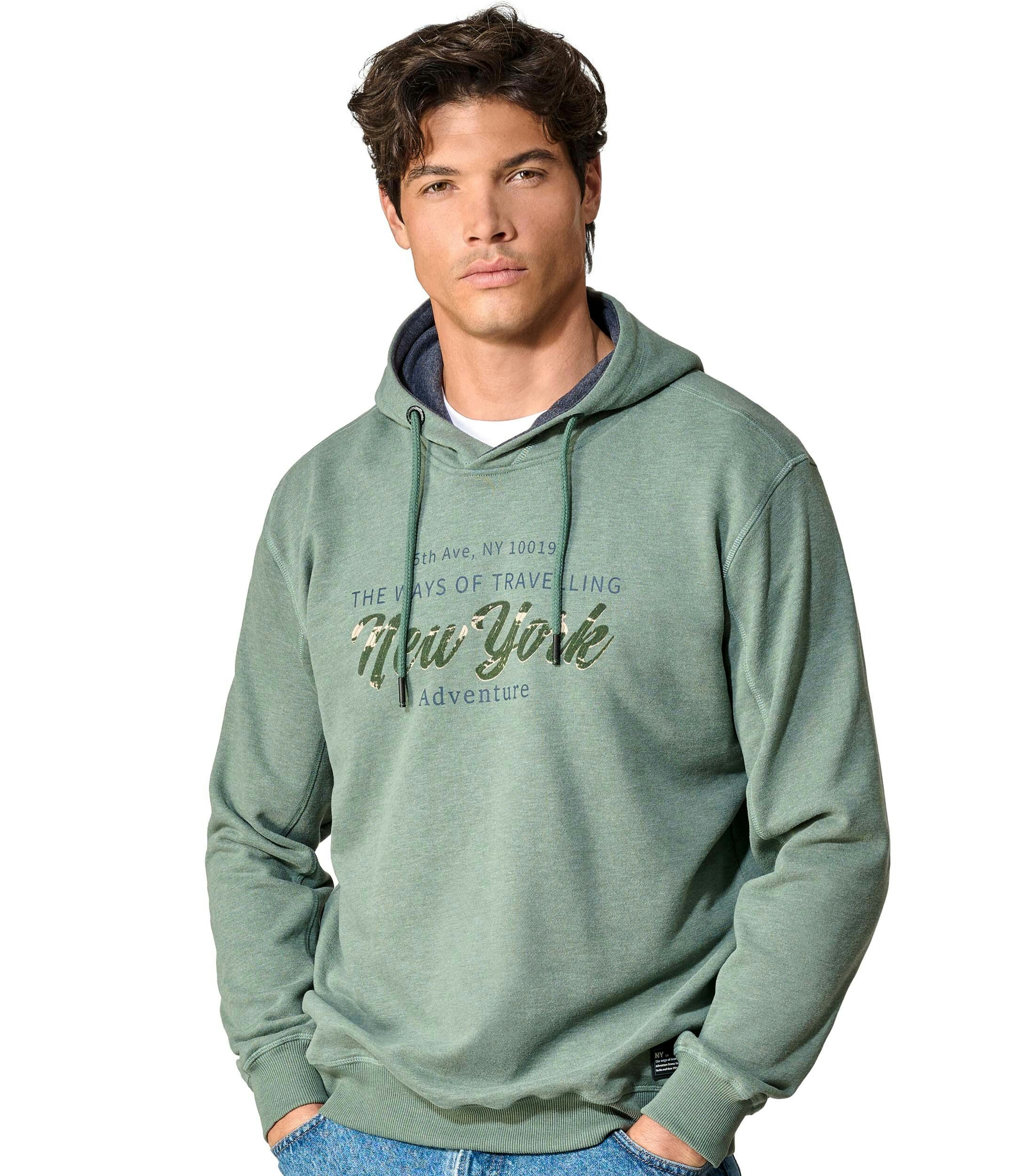 Das Model trägt ein Sweatshirt im uni Muster in der Farbe Grün