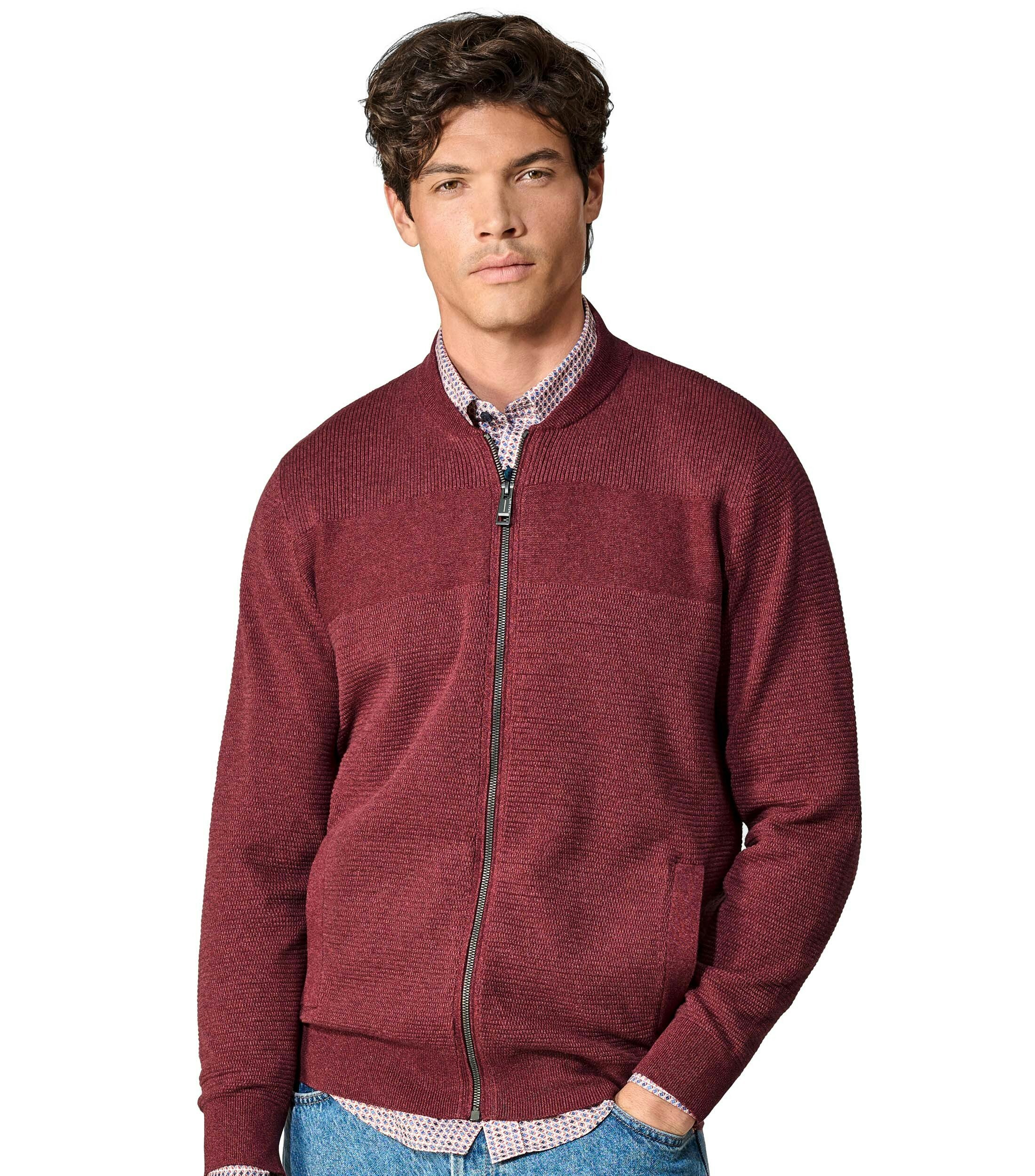 Das Model trägt eine Strickjacke im uni Muster in der Farbe Rot