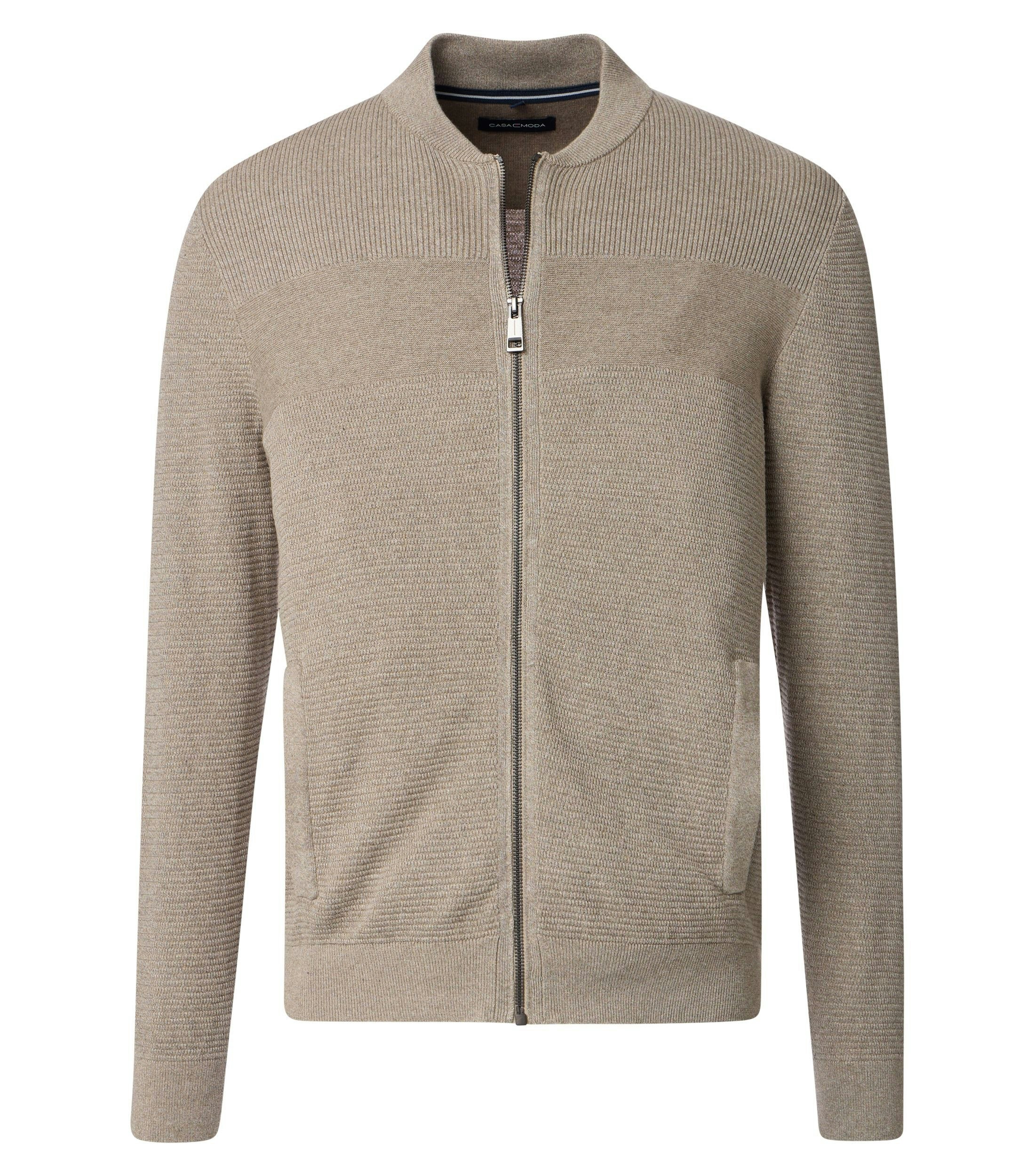 Das Model trägt eine Strickjacke im uni Muster in der Farbe Beige