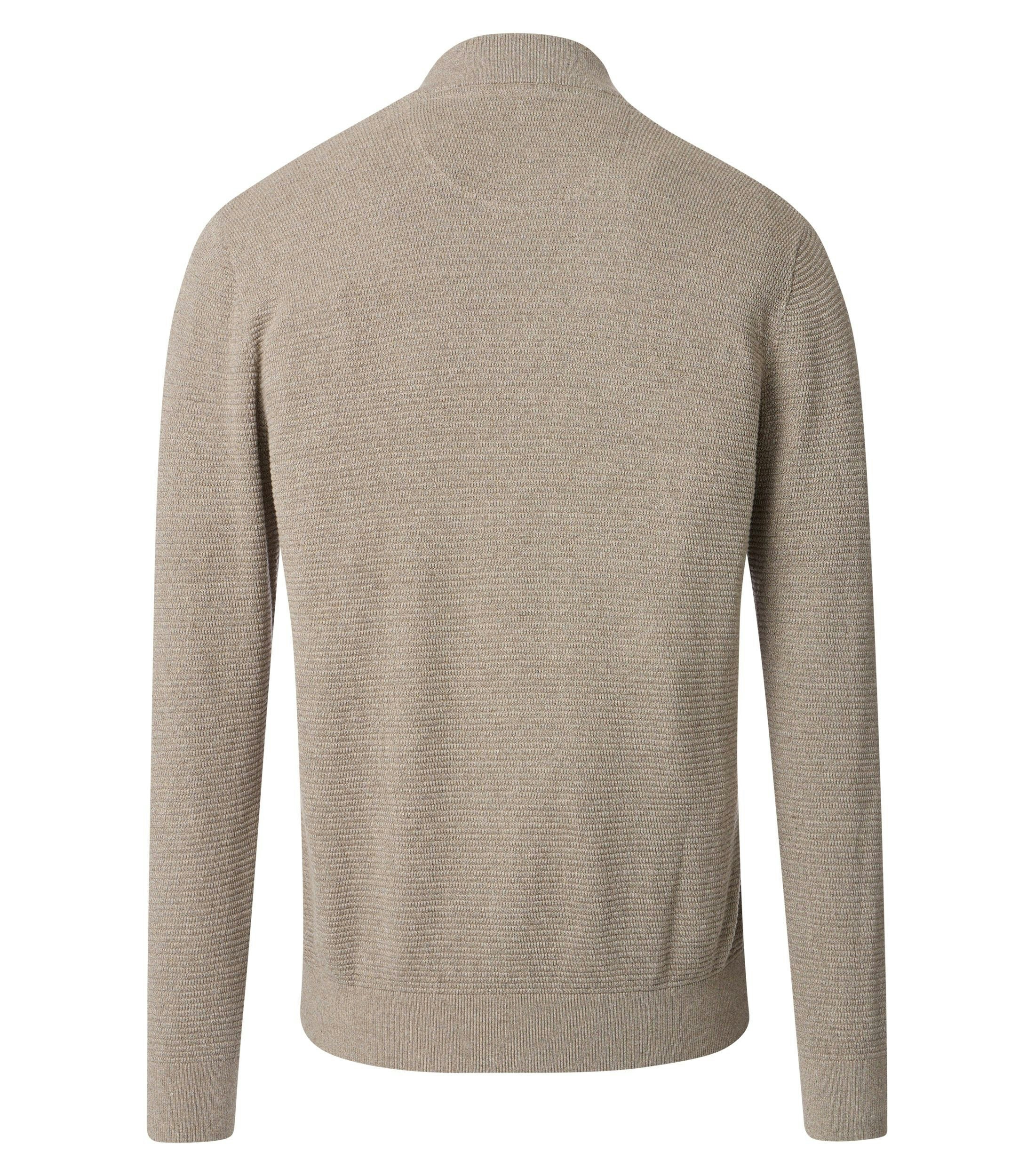 Das Model trägt eine Strickjacke im uni Muster in der Farbe Beige