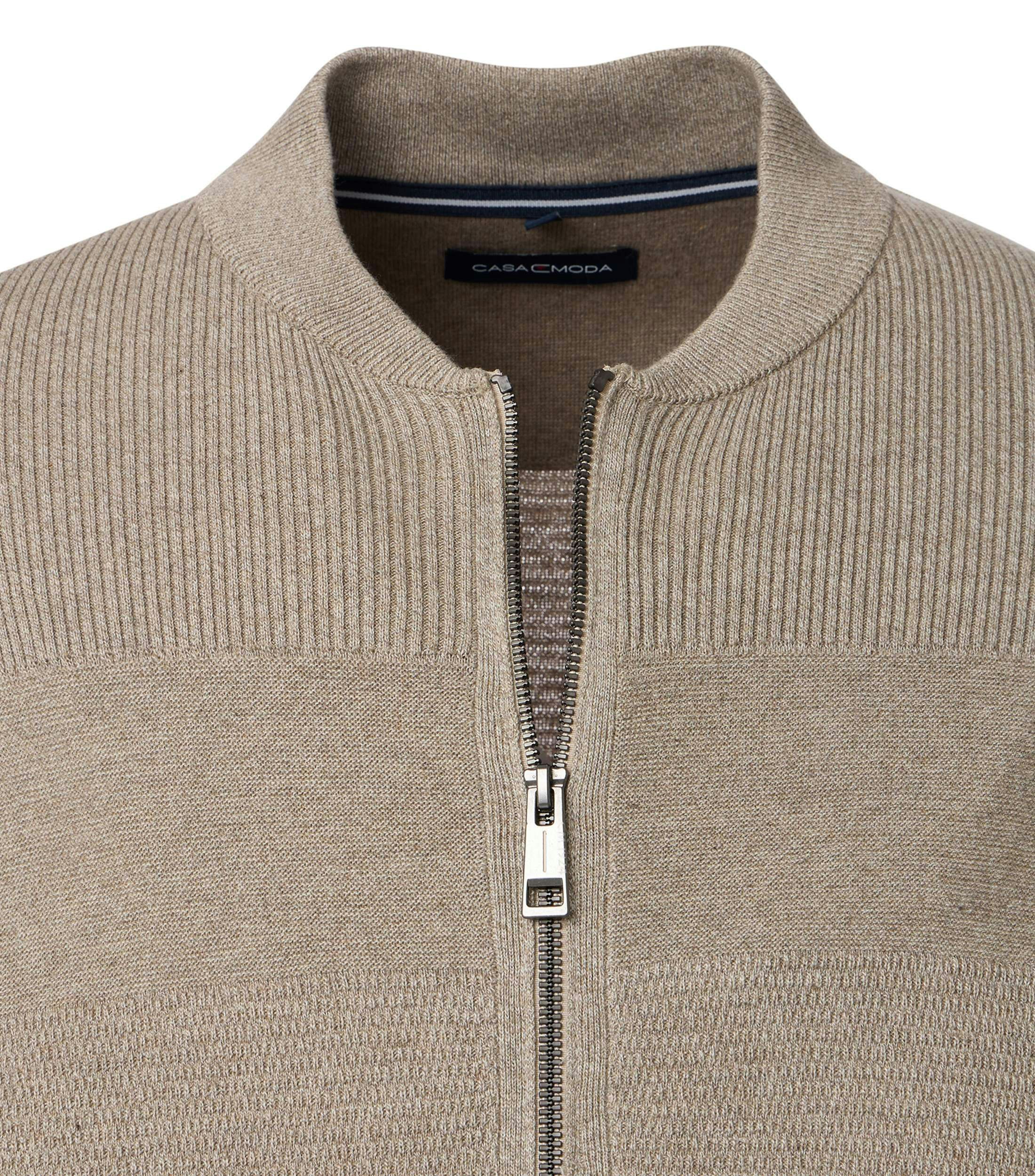 Das Model trägt eine Strickjacke im uni Muster in der Farbe Beige