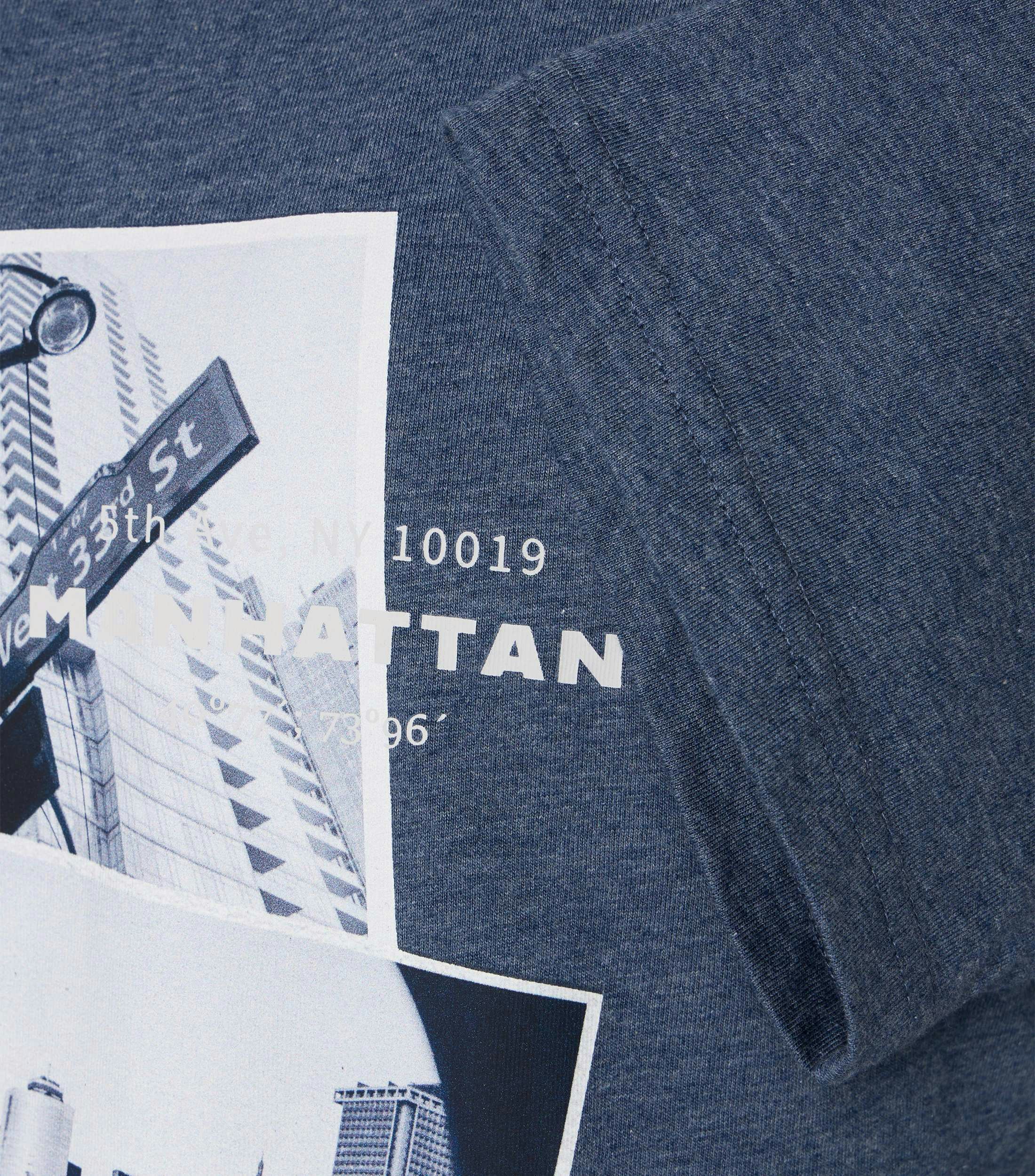 Das Model trägt ein TShirt im uni Muster in der Farbe Mittelblau