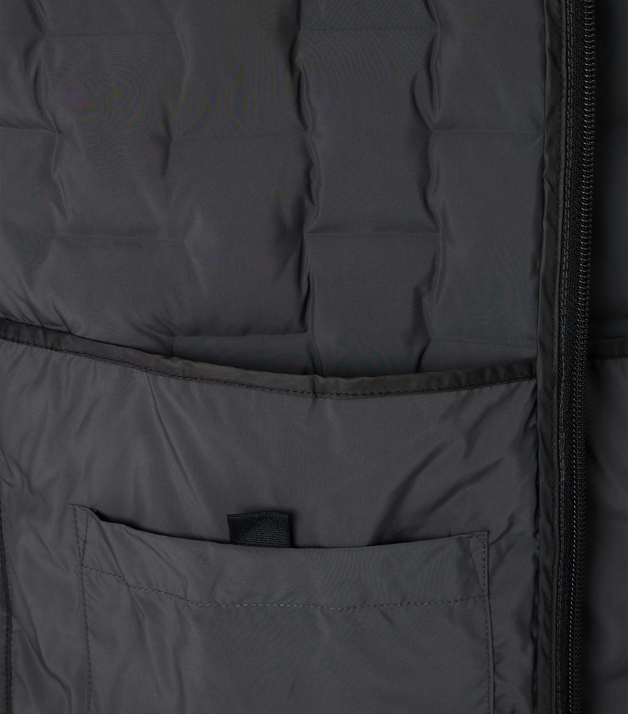 Das Model trägt eine Weste im uni Muster in der Farbe Grau