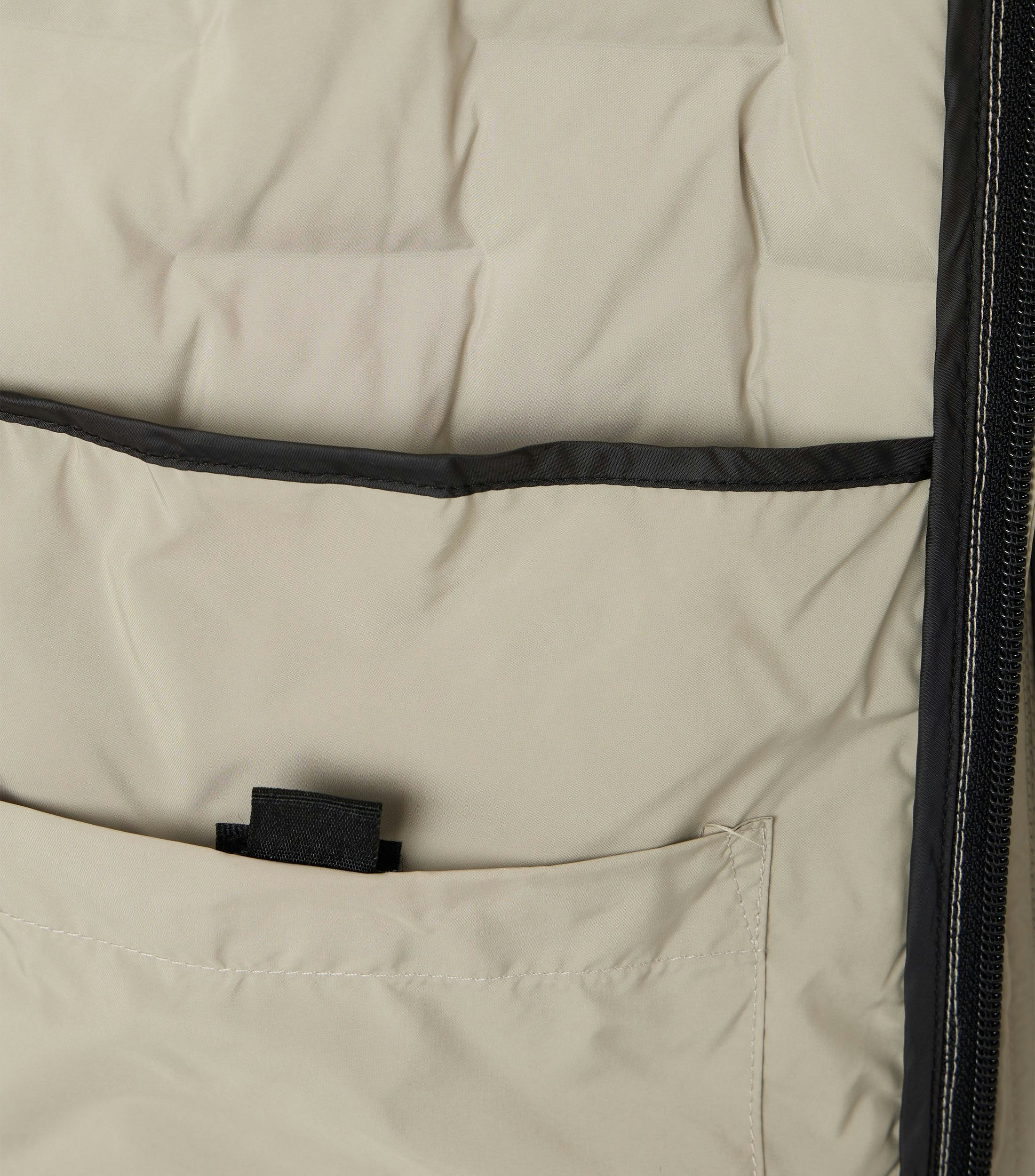 Das Model trägt eine Weste im uni Muster in der Farbe Weißbeige