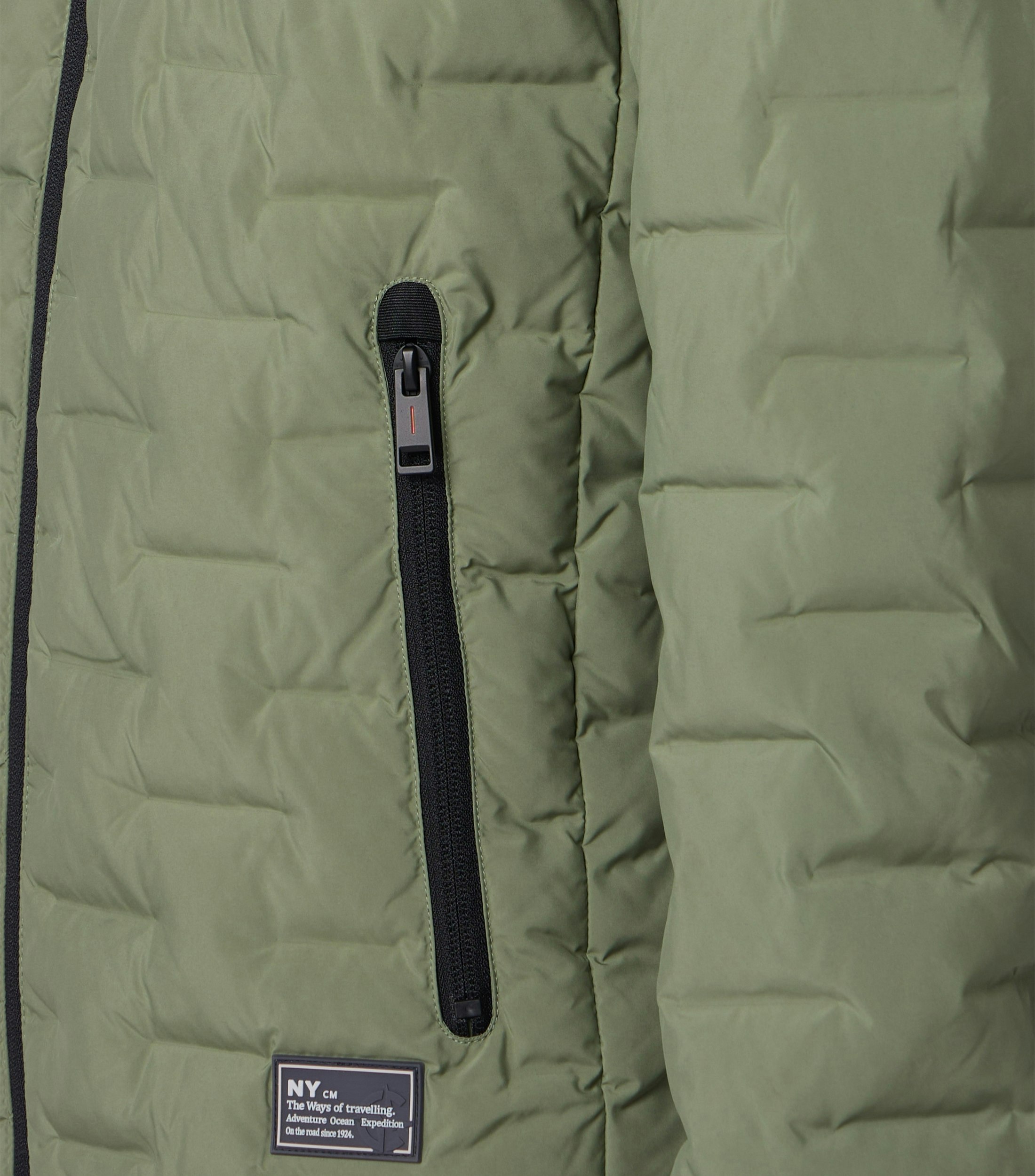 Das Model trägt eine Jacke im uni Muster in der Farbe Hellgrün