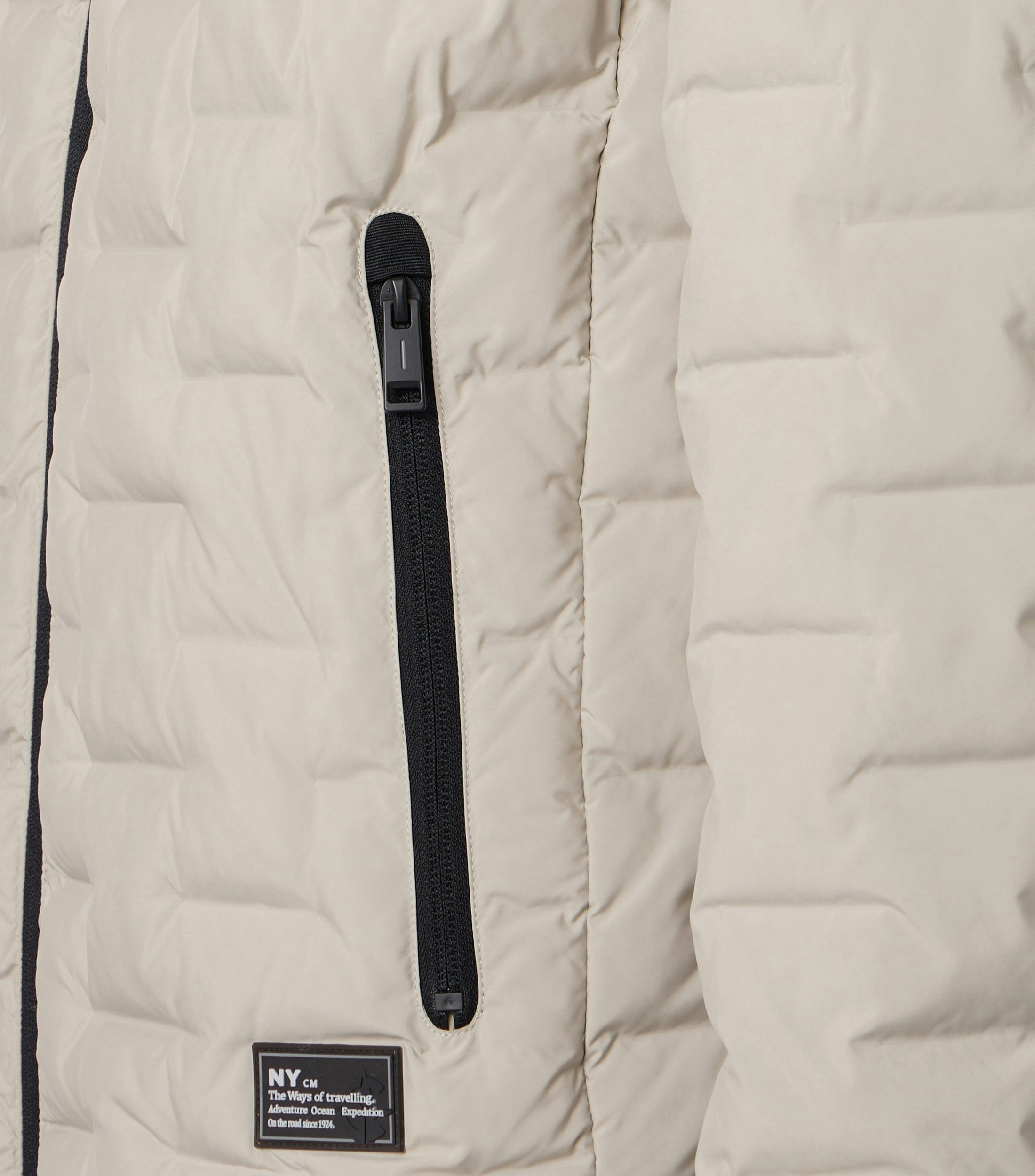 Das Model trägt eine Jacke im uni Muster in der Farbe Weißbeige