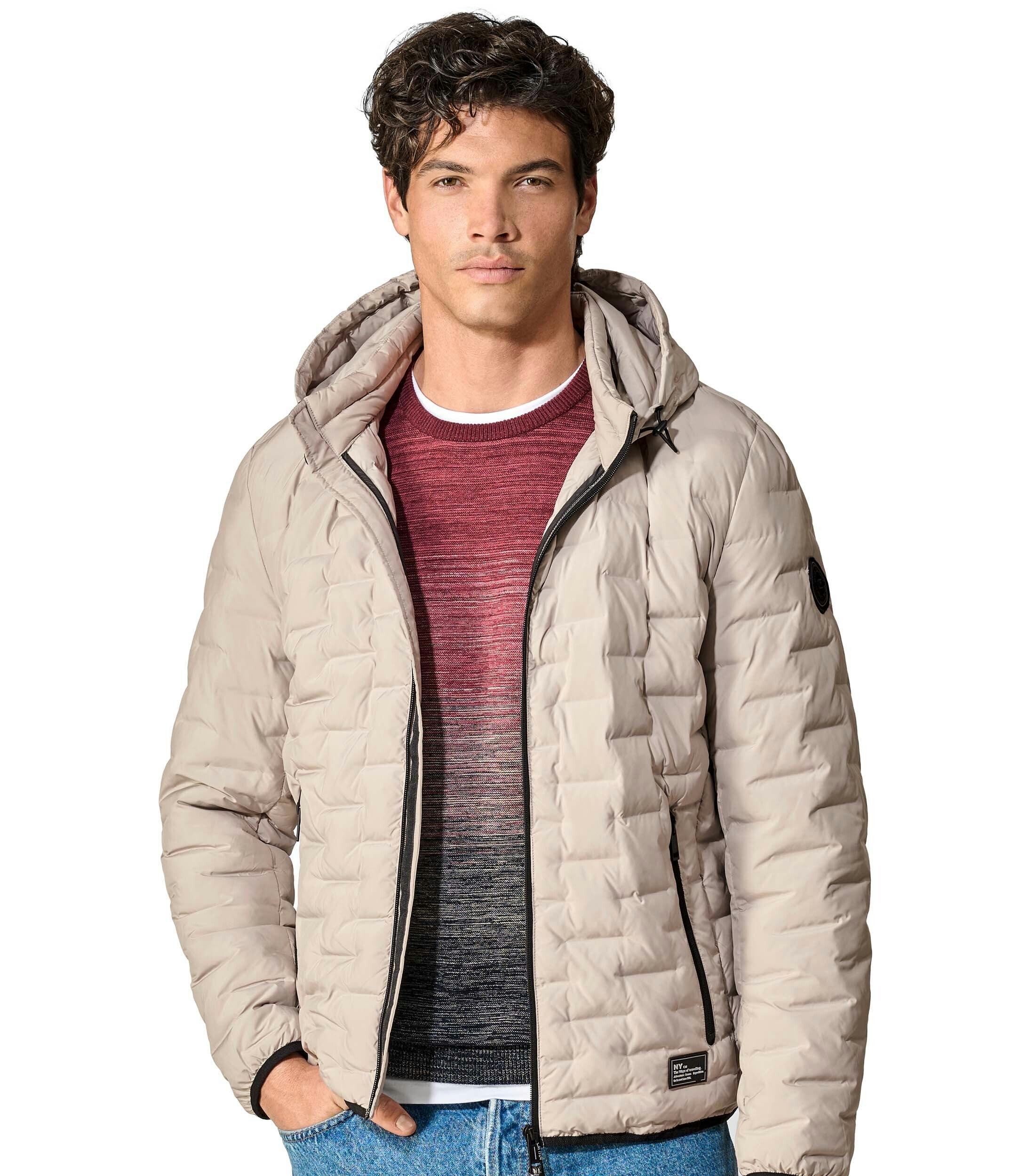 Das Model trägt eine Jacke im uni Muster in der Farbe Weißbeige