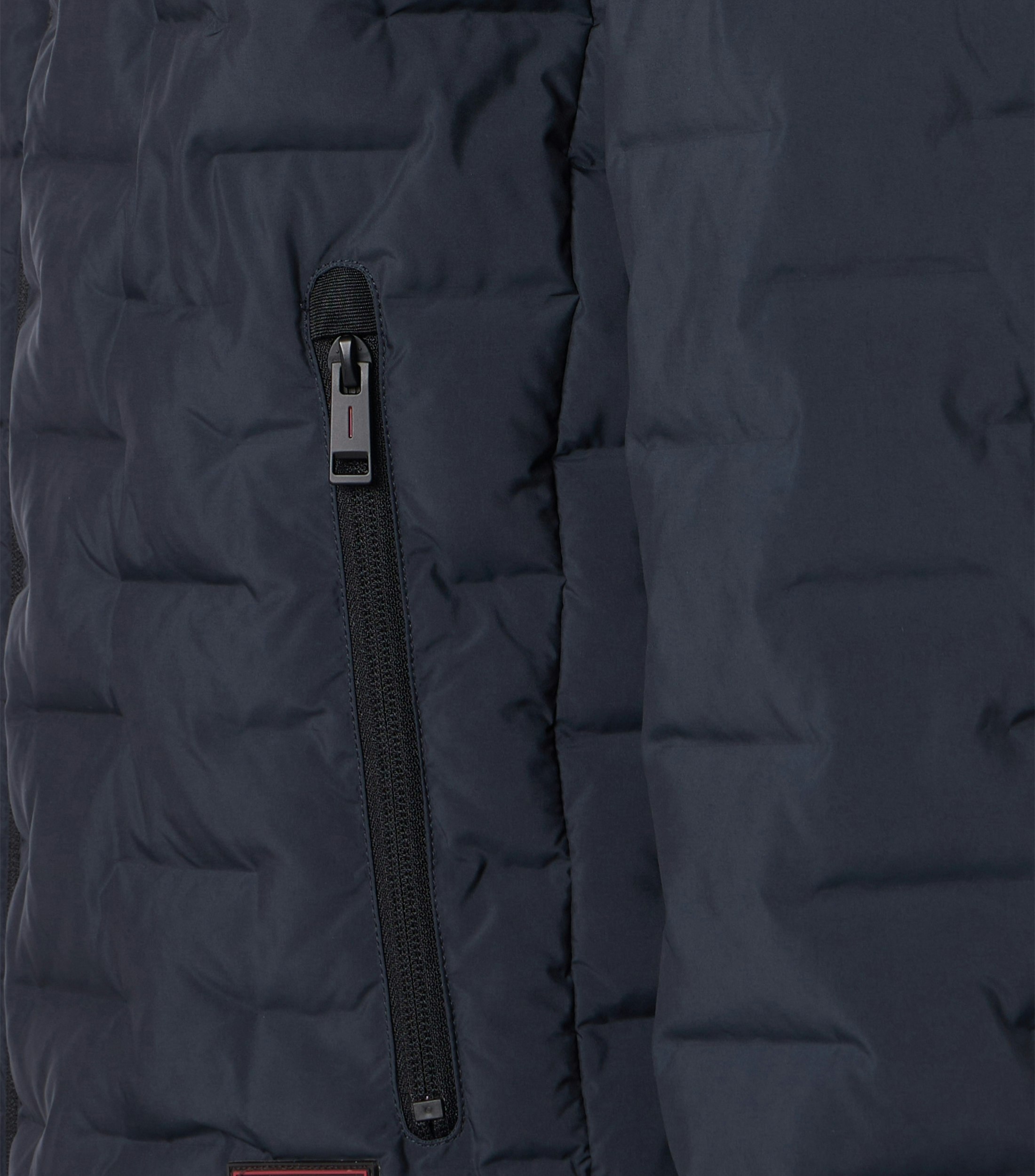 Das Model trägt eine Jacke im uni Muster in der Farbe Dunkelblau