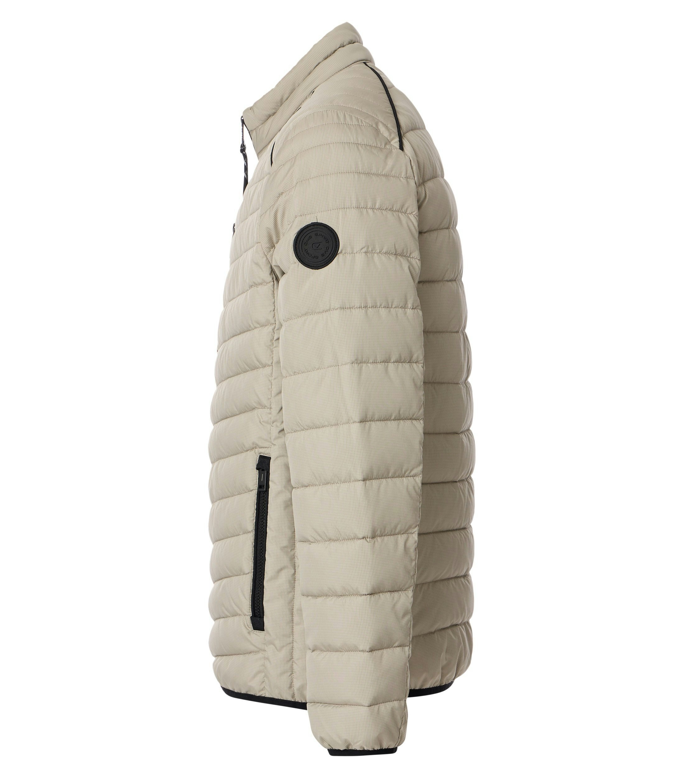 Das Model trägt eine Jacke im uni Muster in der Farbe Weißbeige