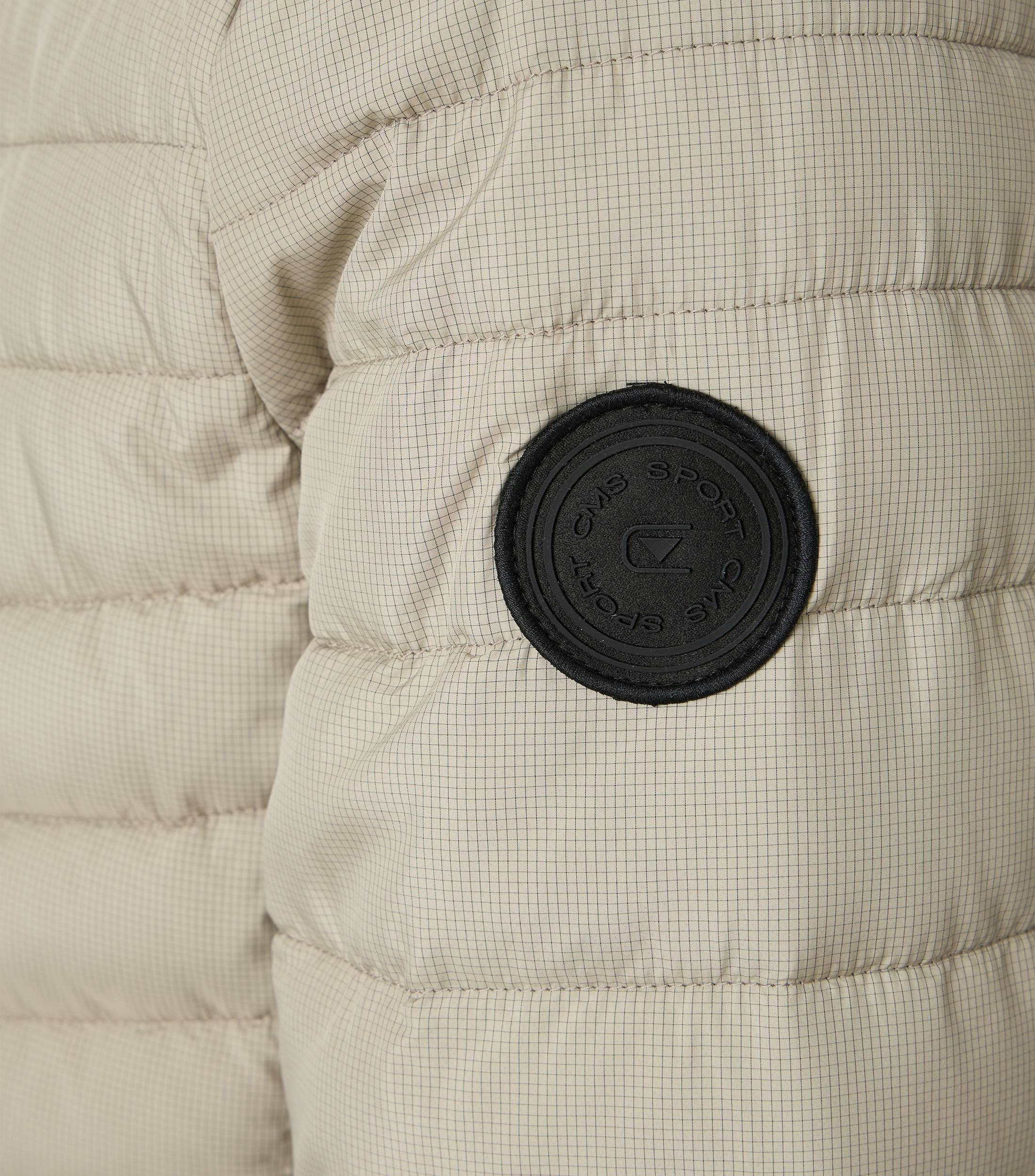 Das Model trägt eine Jacke im uni Muster in der Farbe Weißbeige