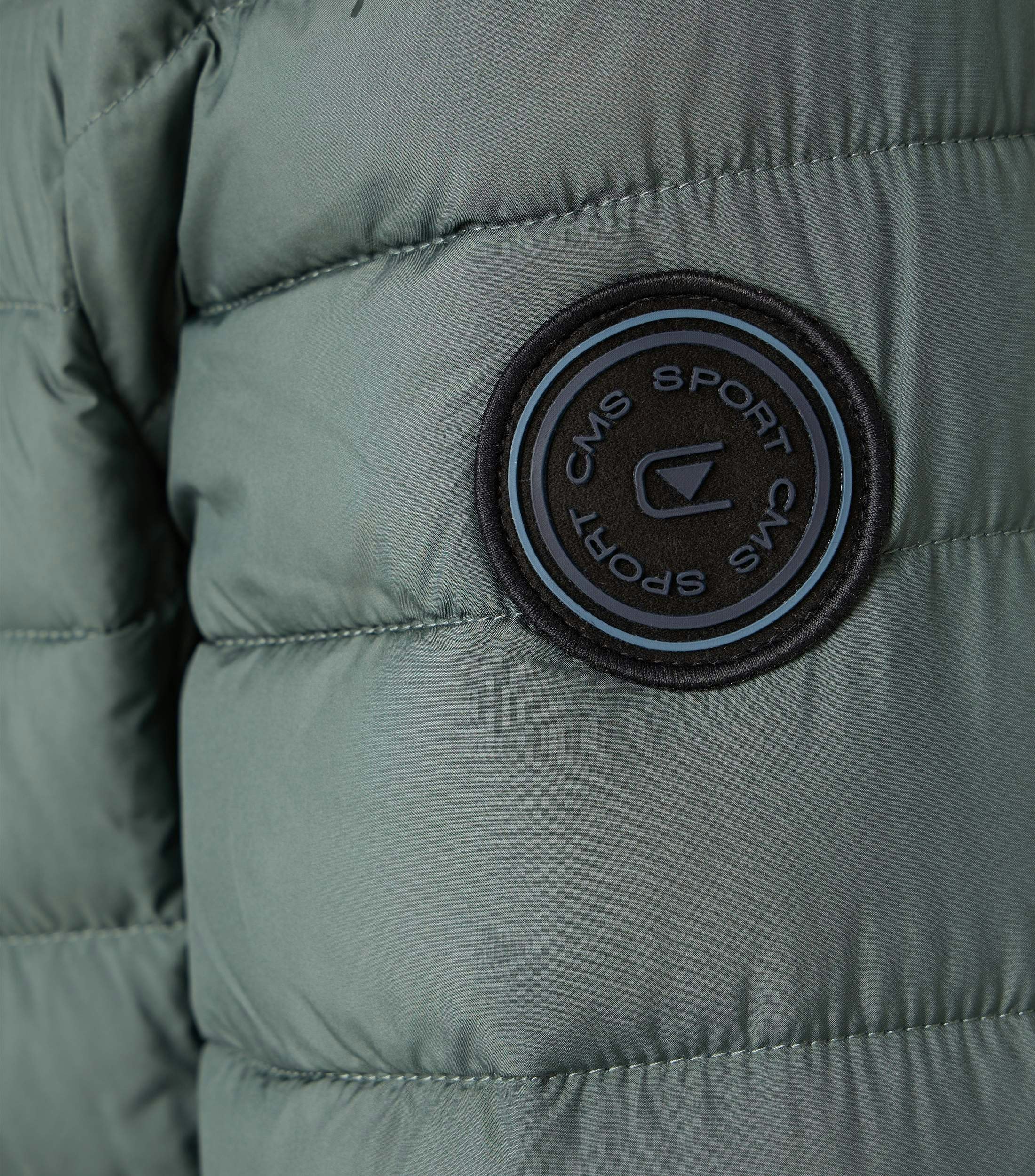 Das Model trägt eine Jacke im uni Muster in der Farbe Grün