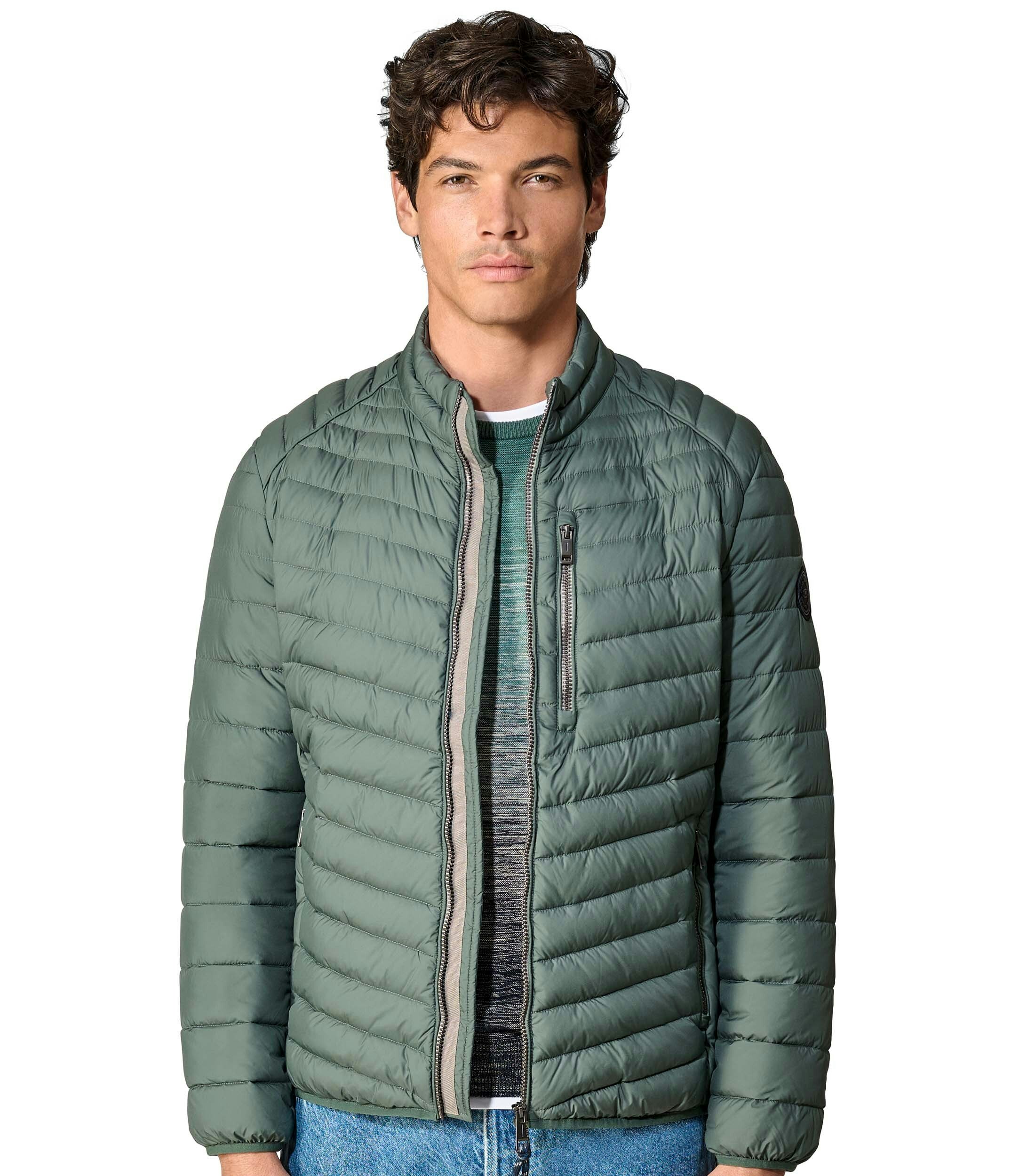 Das Model trägt eine Jacke im uni Muster in der Farbe Grün