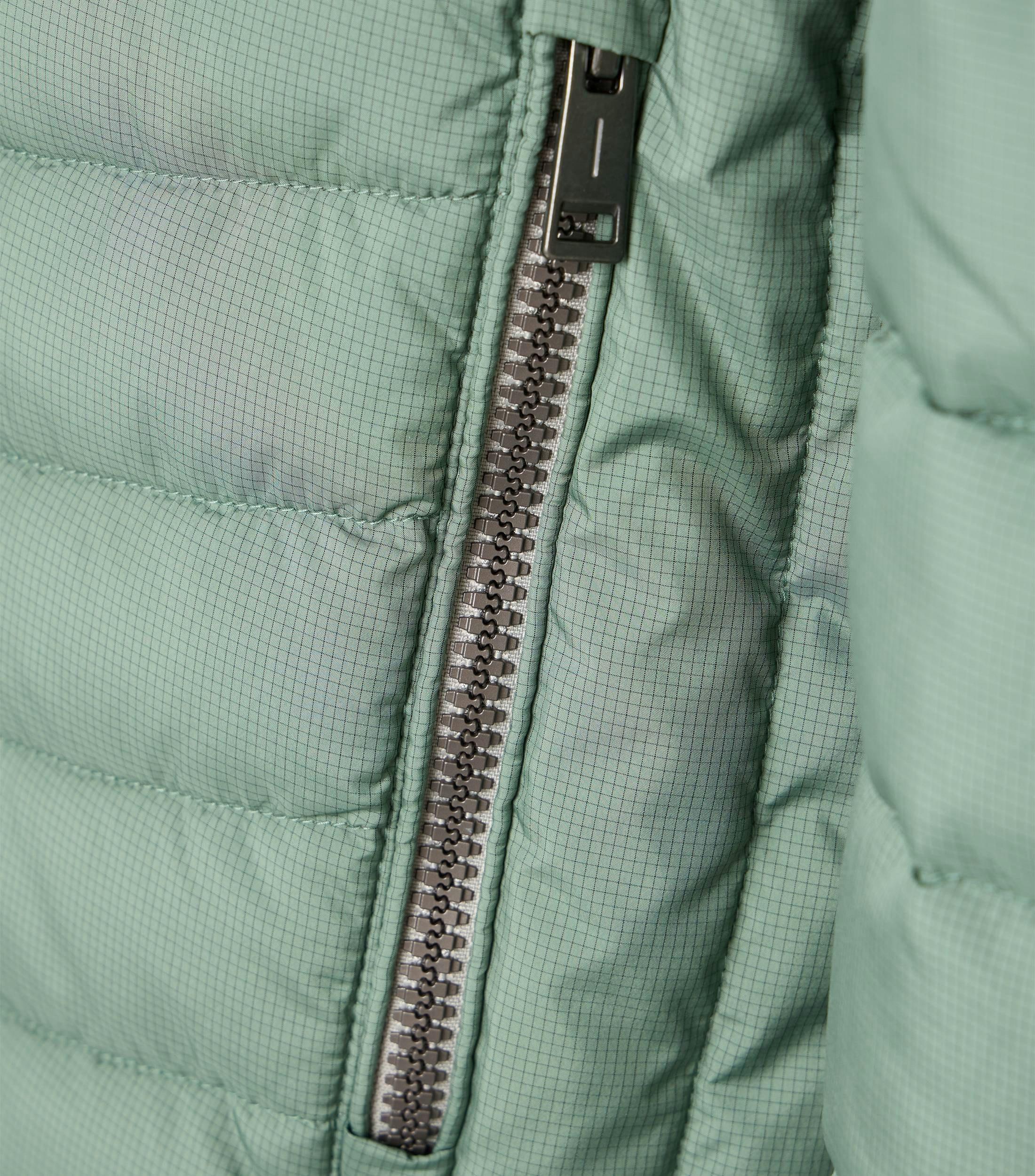 Das Model trägt eine Jacke im uni Muster in der Farbe Mint