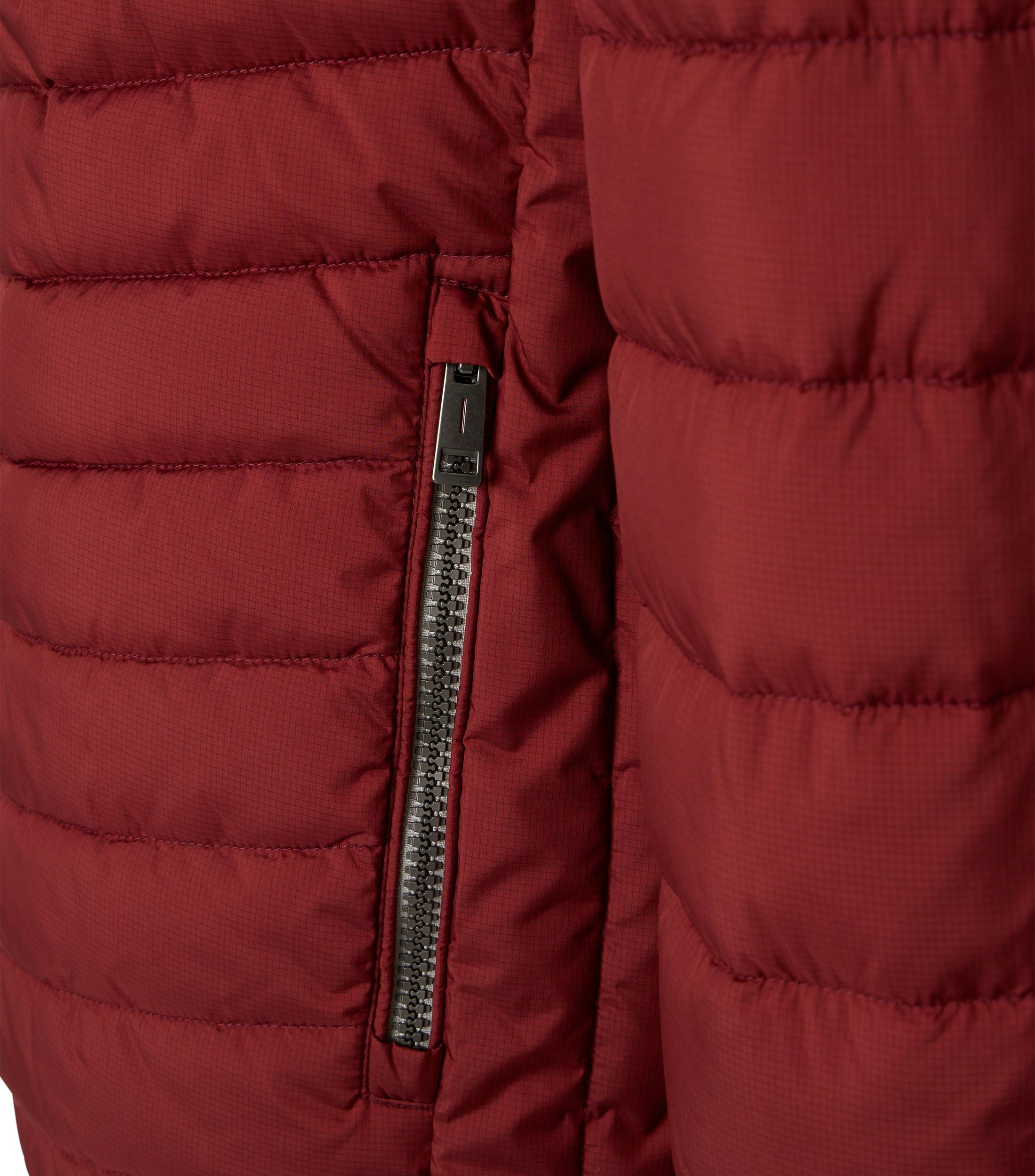 Das Model trägt eine Jacke im uni Muster in der Farbe Rot