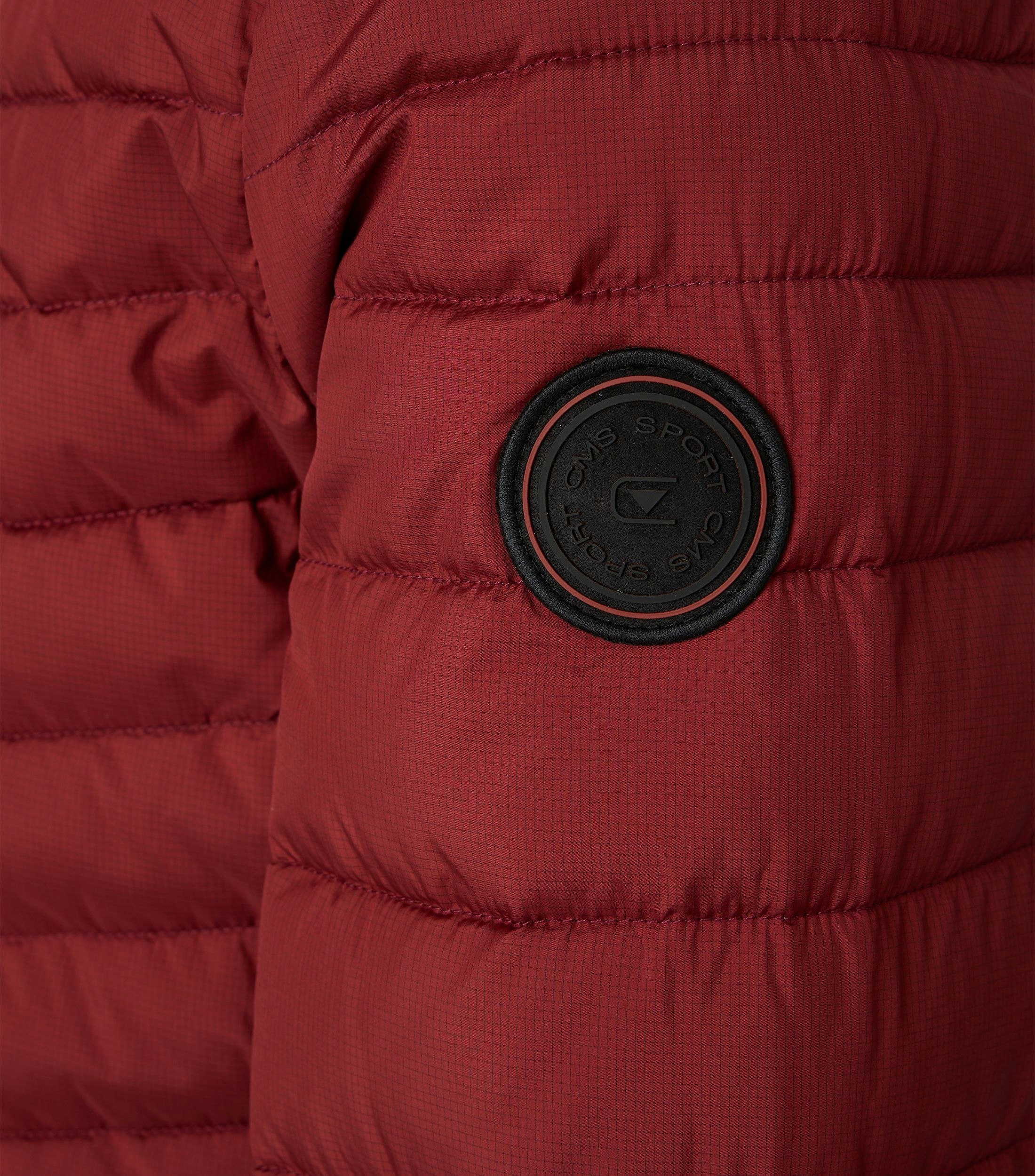 Das Model trägt eine Jacke im uni Muster in der Farbe Rot