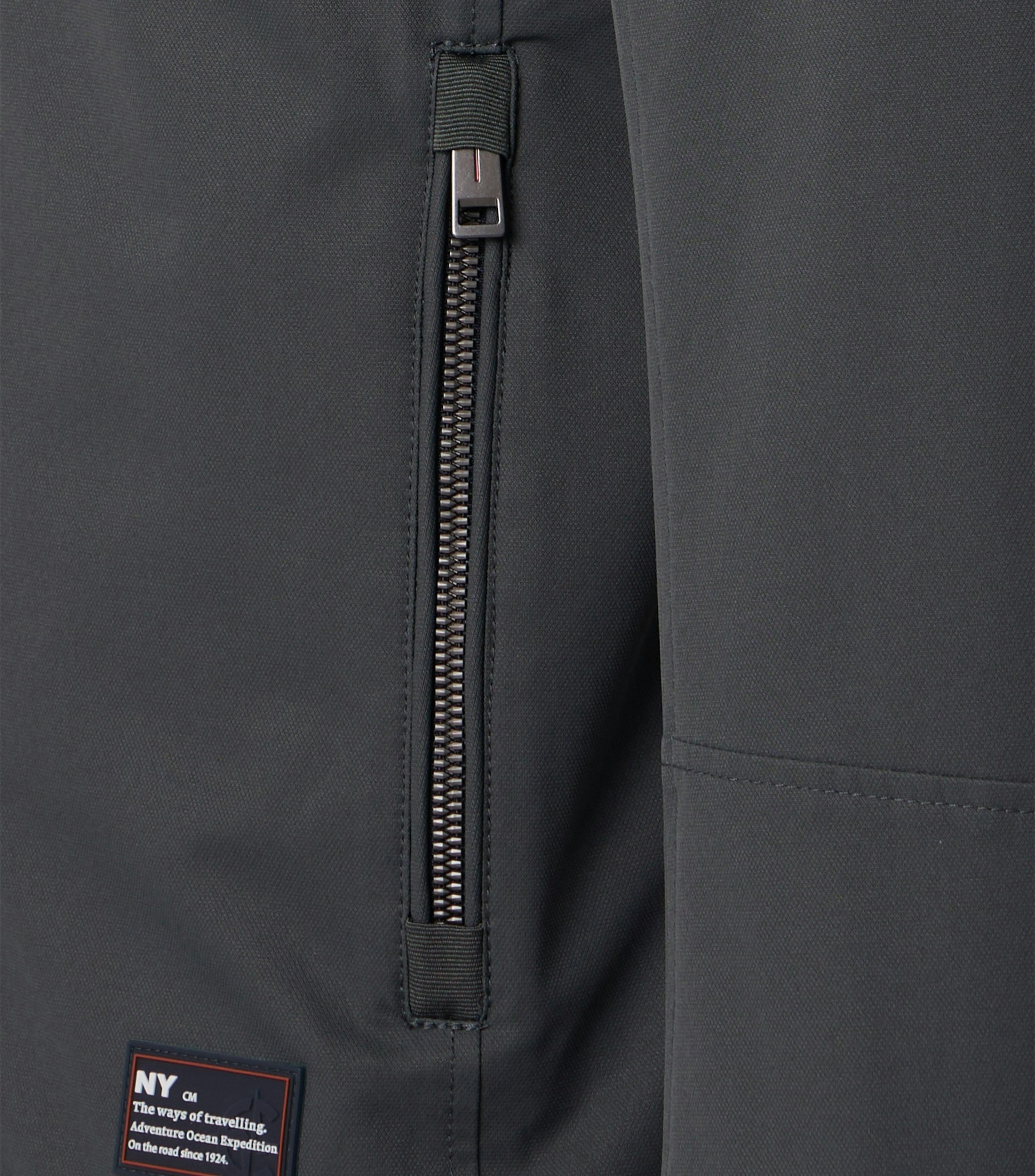 Das Model trägt eine Jacke im uni Muster in der Farbe Grau