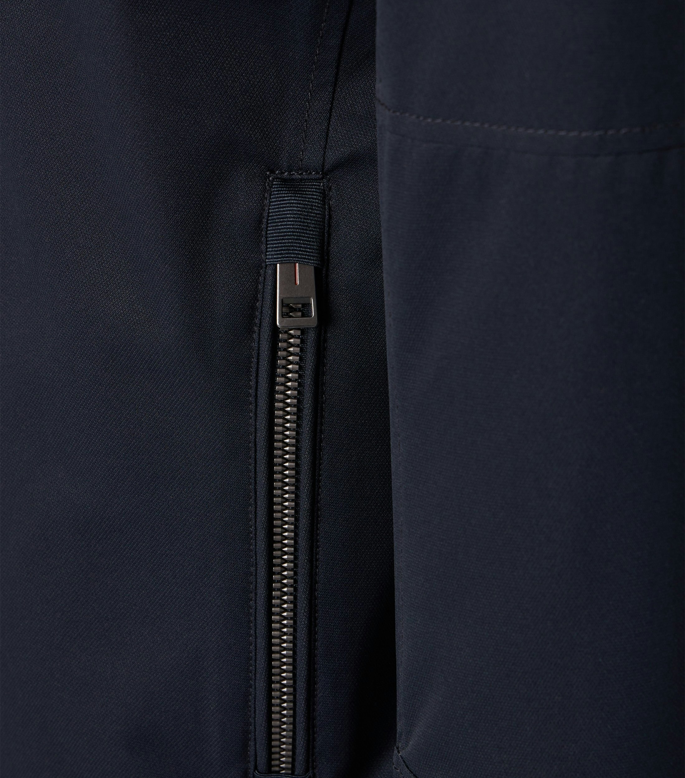 Das Model trägt eine Jacke im uni Muster in der Farbe Dunkelblau