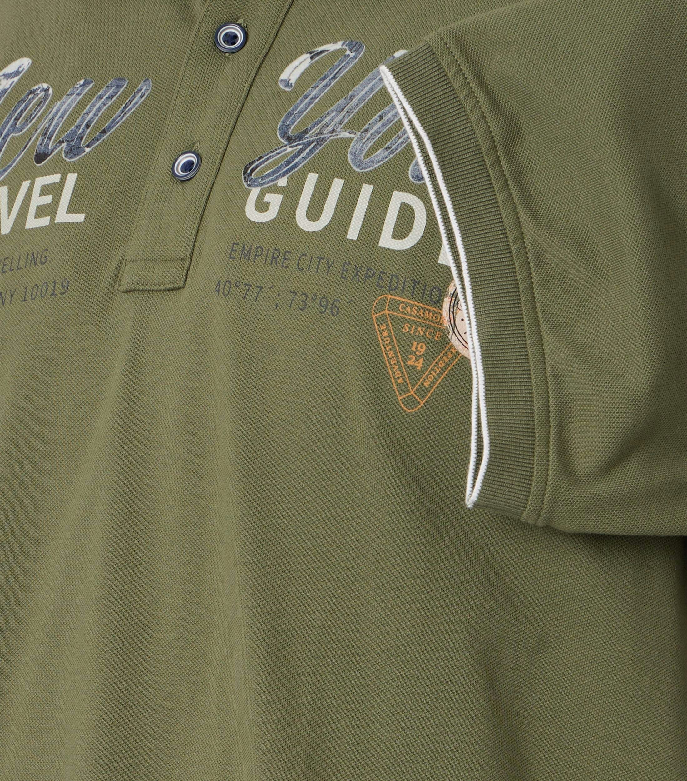 Das Model trägt ein PoloShirt im uni Muster in der Farbe Grün