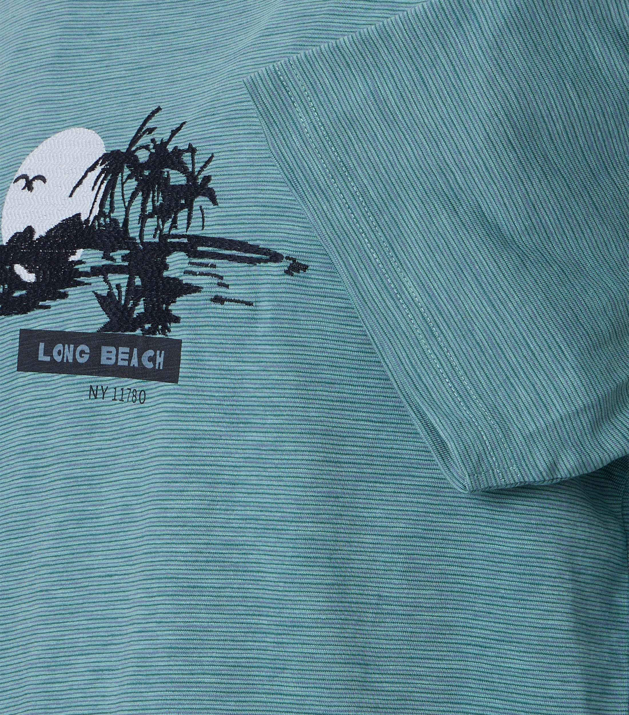 Das Model trägt ein TShirt im Print Muster in der Farbe Türkis