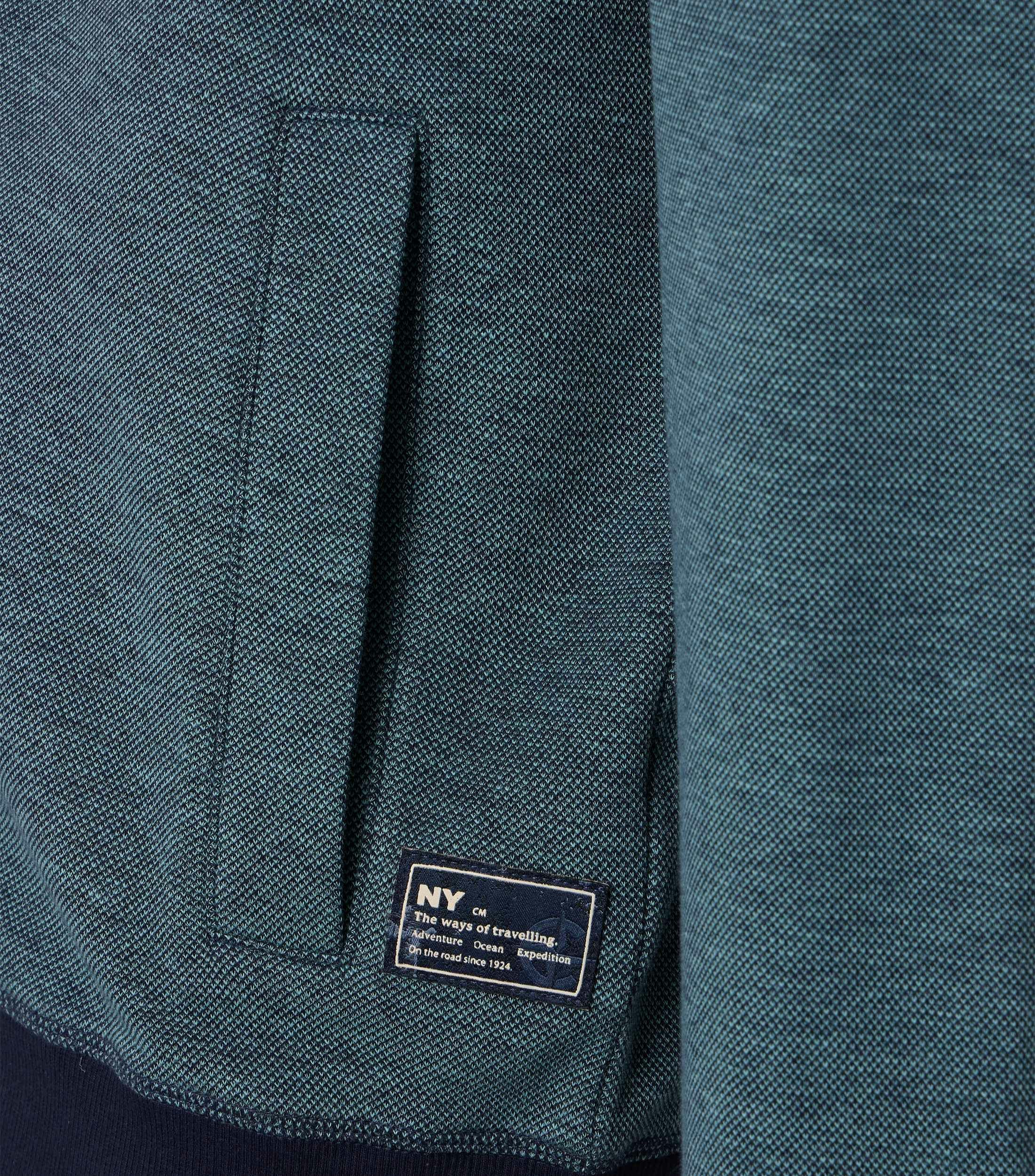 Das Model trägt eine Sweatjacke im uni Muster in der Farbe Türkis