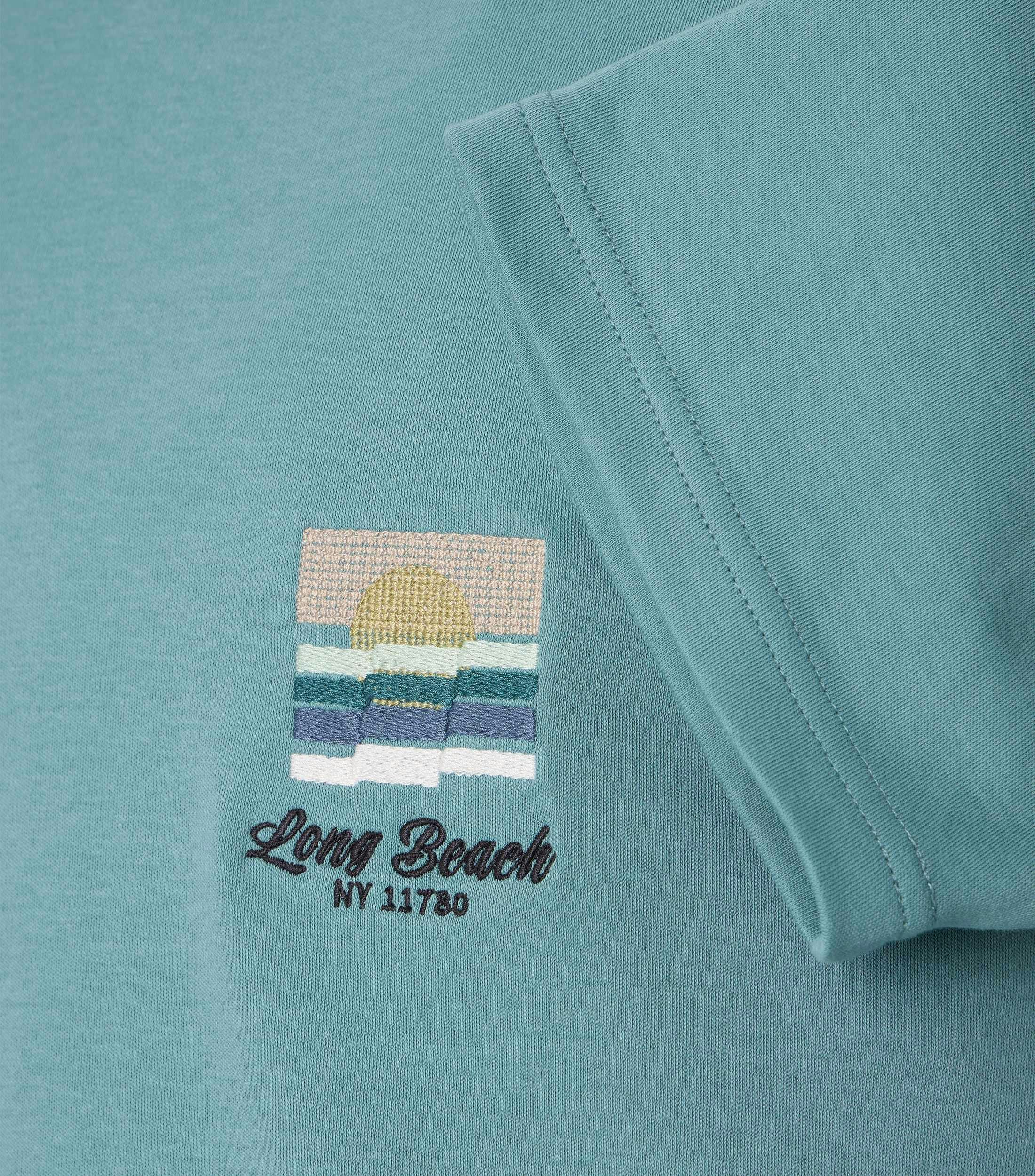 Das Model trägt ein TShirt im uni Muster in der Farbe Türkis