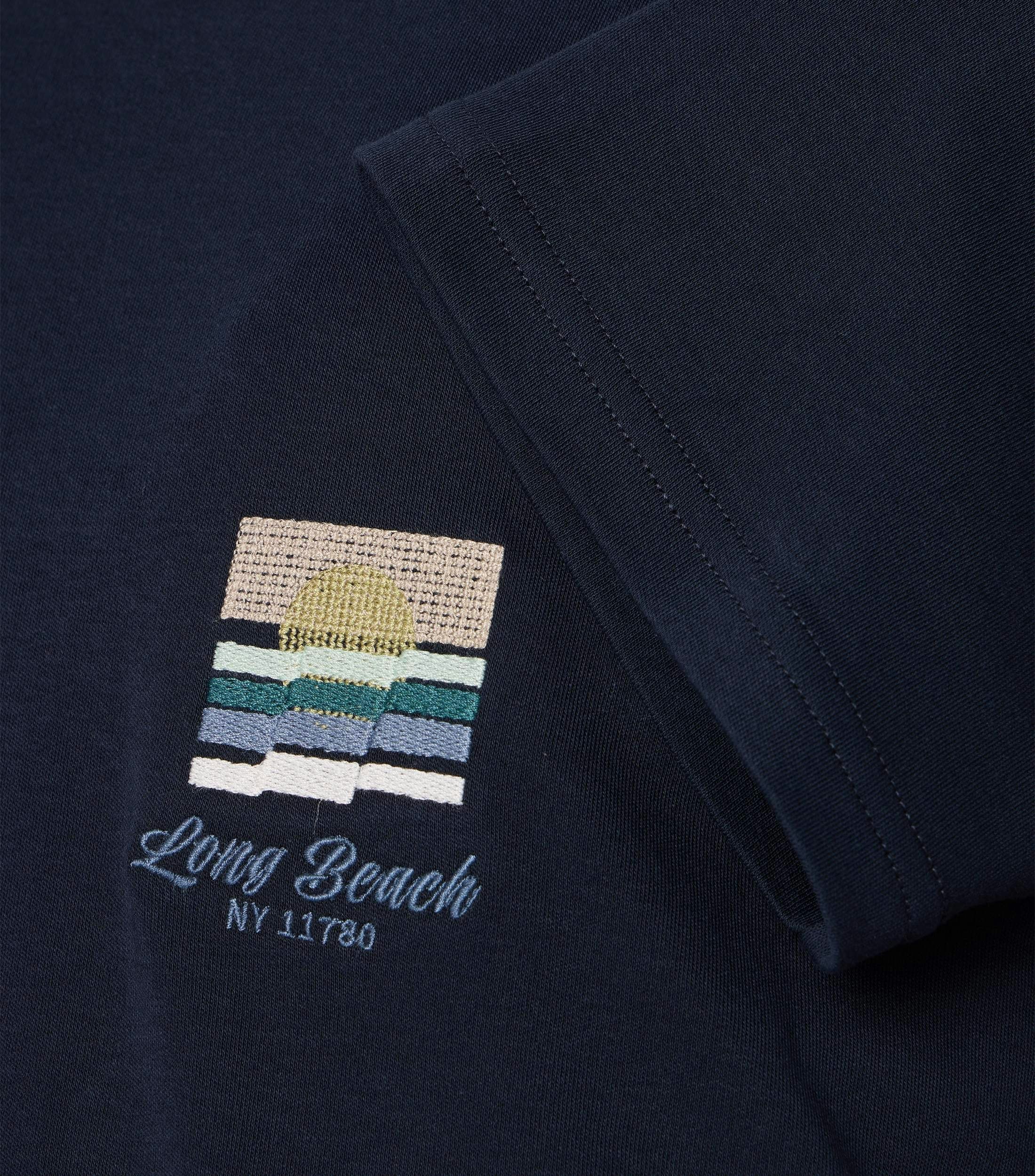 Das Model trägt ein TShirt im uni Muster in der Farbe Dunkelblau