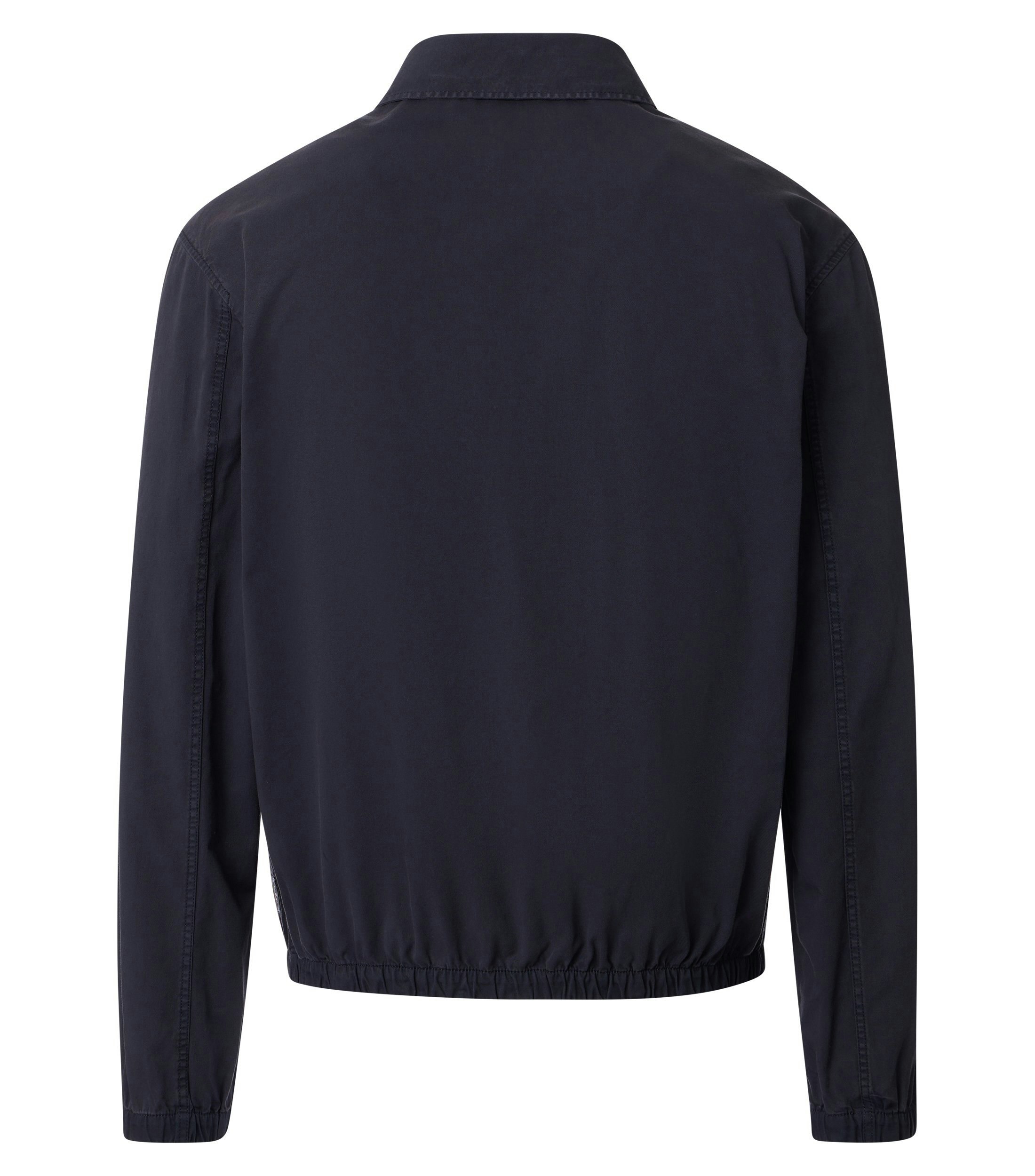 Das Model trägt eine Jacke im uni Muster in der Farbe Blau