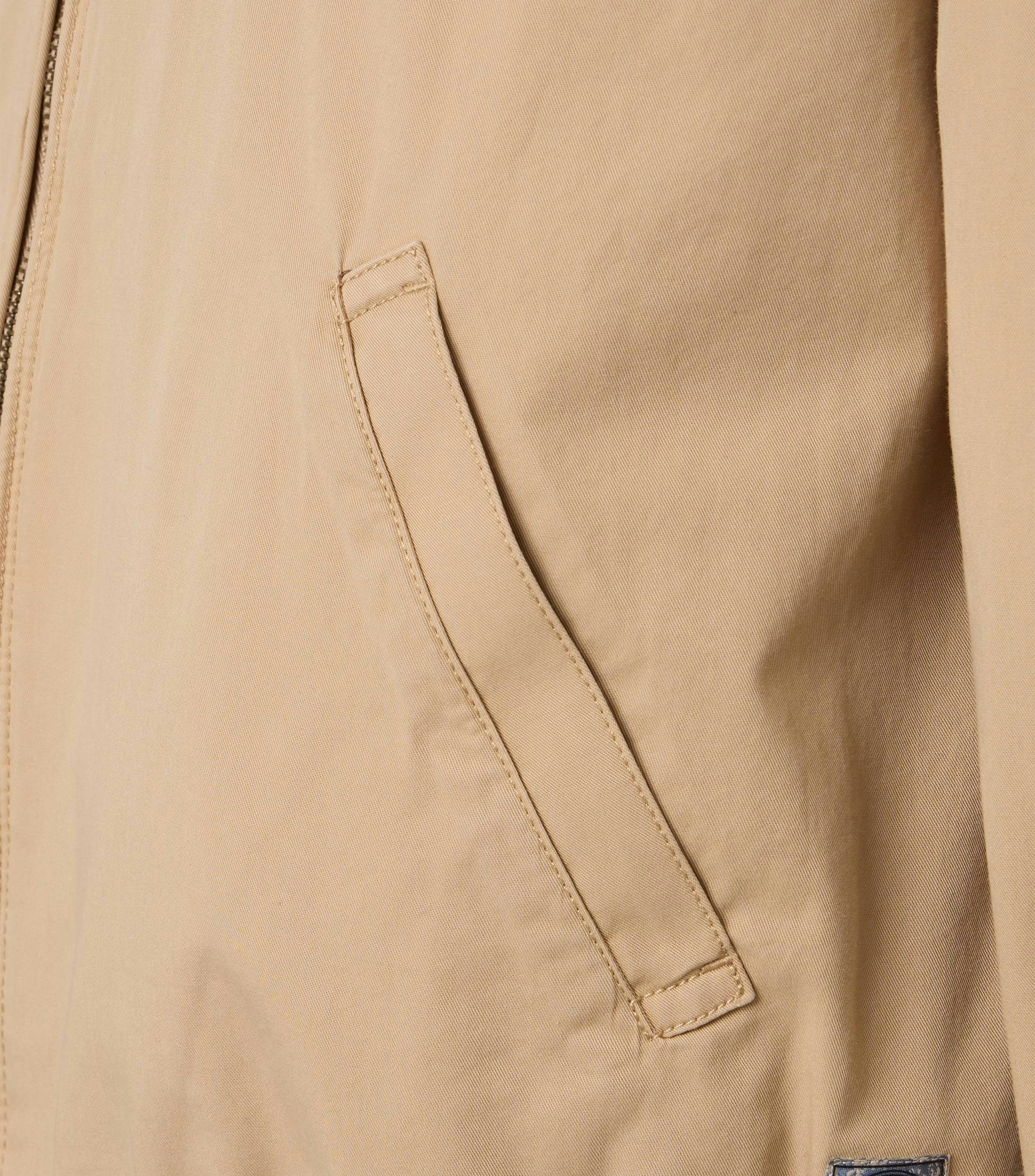 Das Model trägt eine Jacke im uni Muster in der Farbe Beige