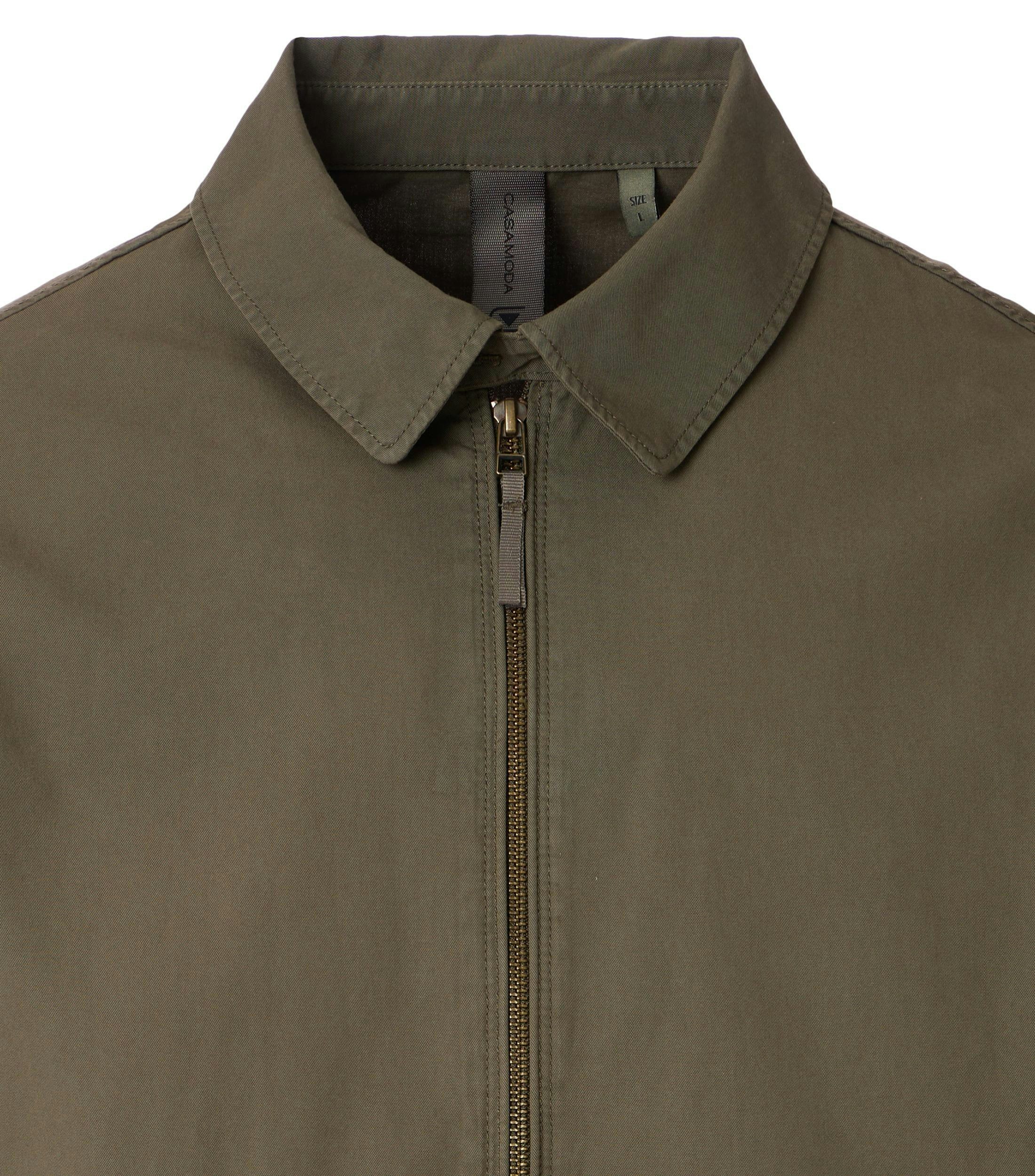 Das Model trägt eine Jacke im uni Muster in der Farbe Dunkelgrün