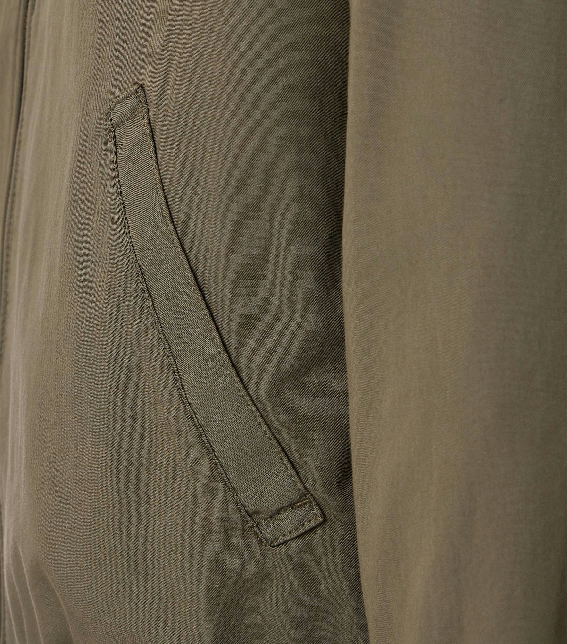 Das Model trägt eine Jacke im uni Muster in der Farbe Dunkelgrün