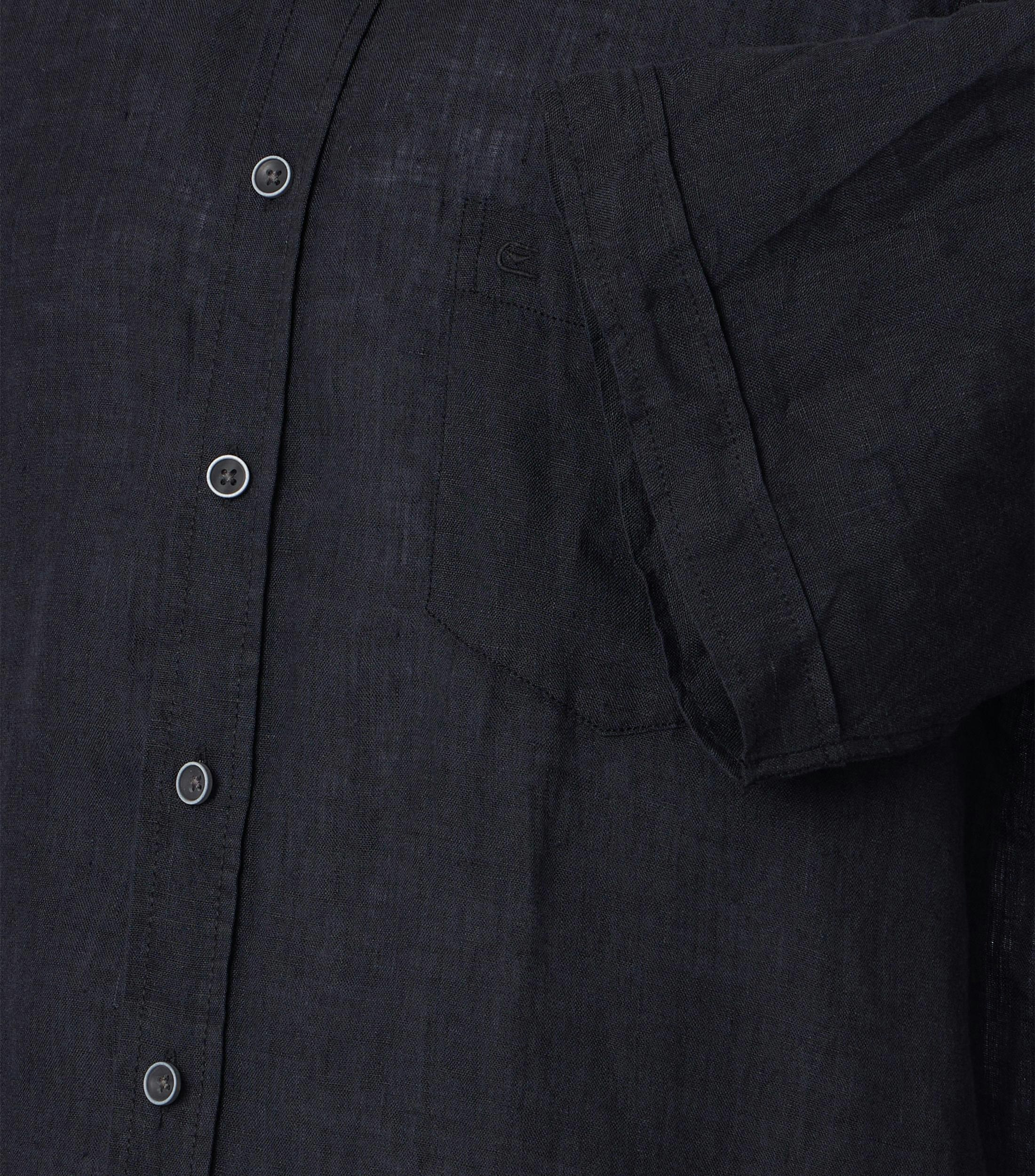 Das Model trägt ein Freizeithemd im uni Muster in der Farbe Schwarz