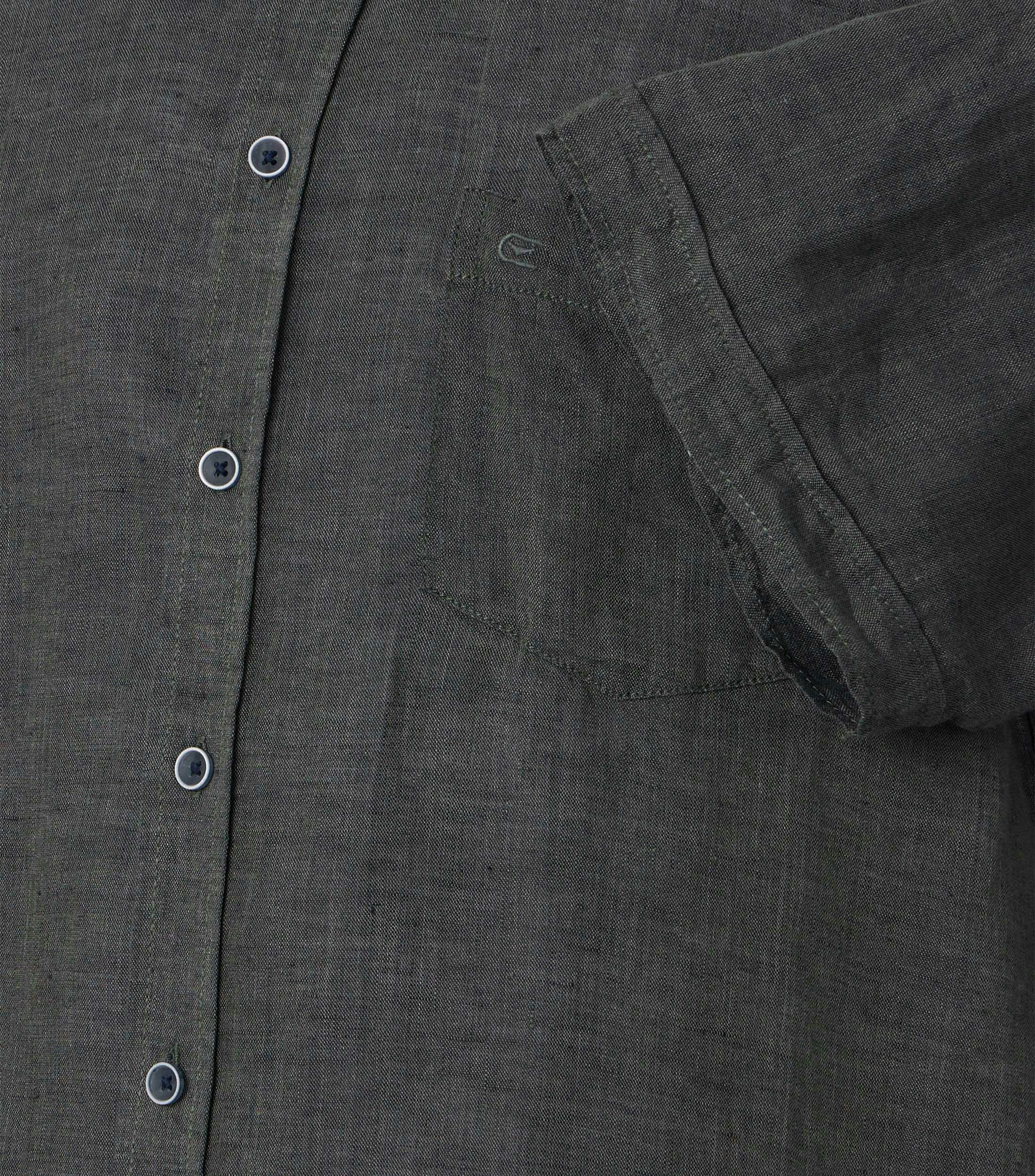 Das Model trägt ein Freizeithemd im uni Muster in der Farbe grün