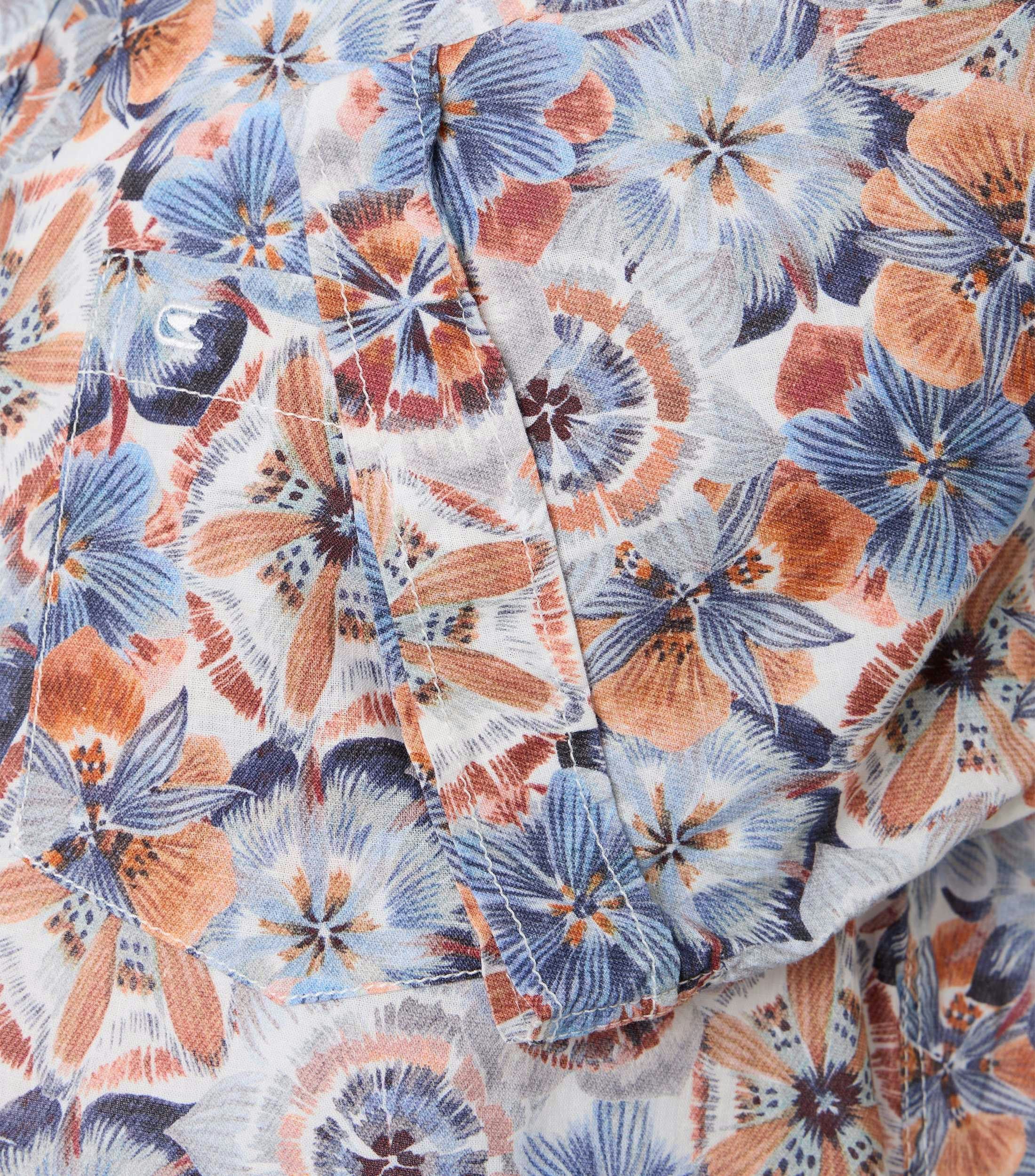 Das Model trägt ein Freizeithemd im Print Muster in der Farbe Orange