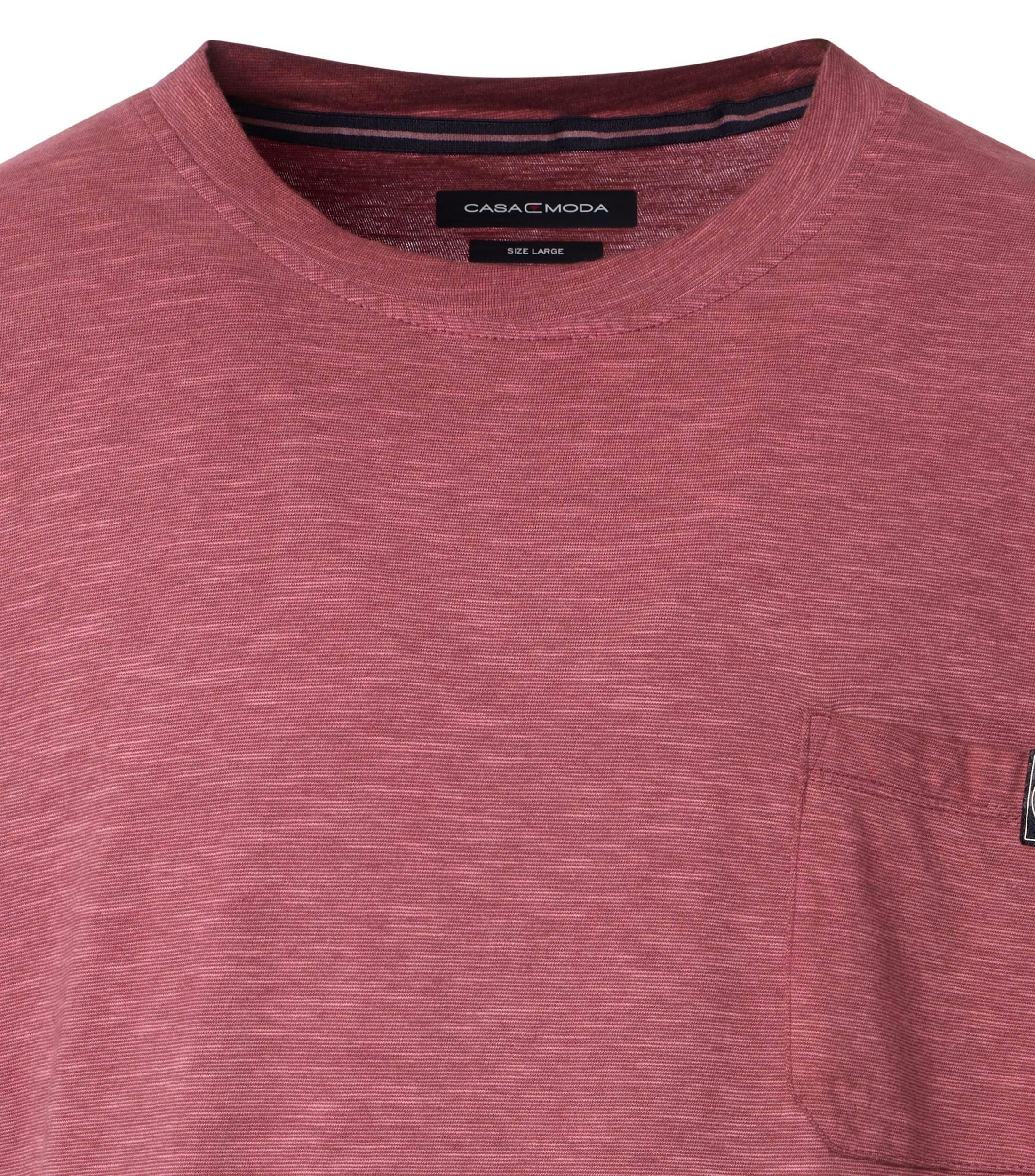 Das Model trägt ein TShirt im uni Muster in der Farbe Rotorange