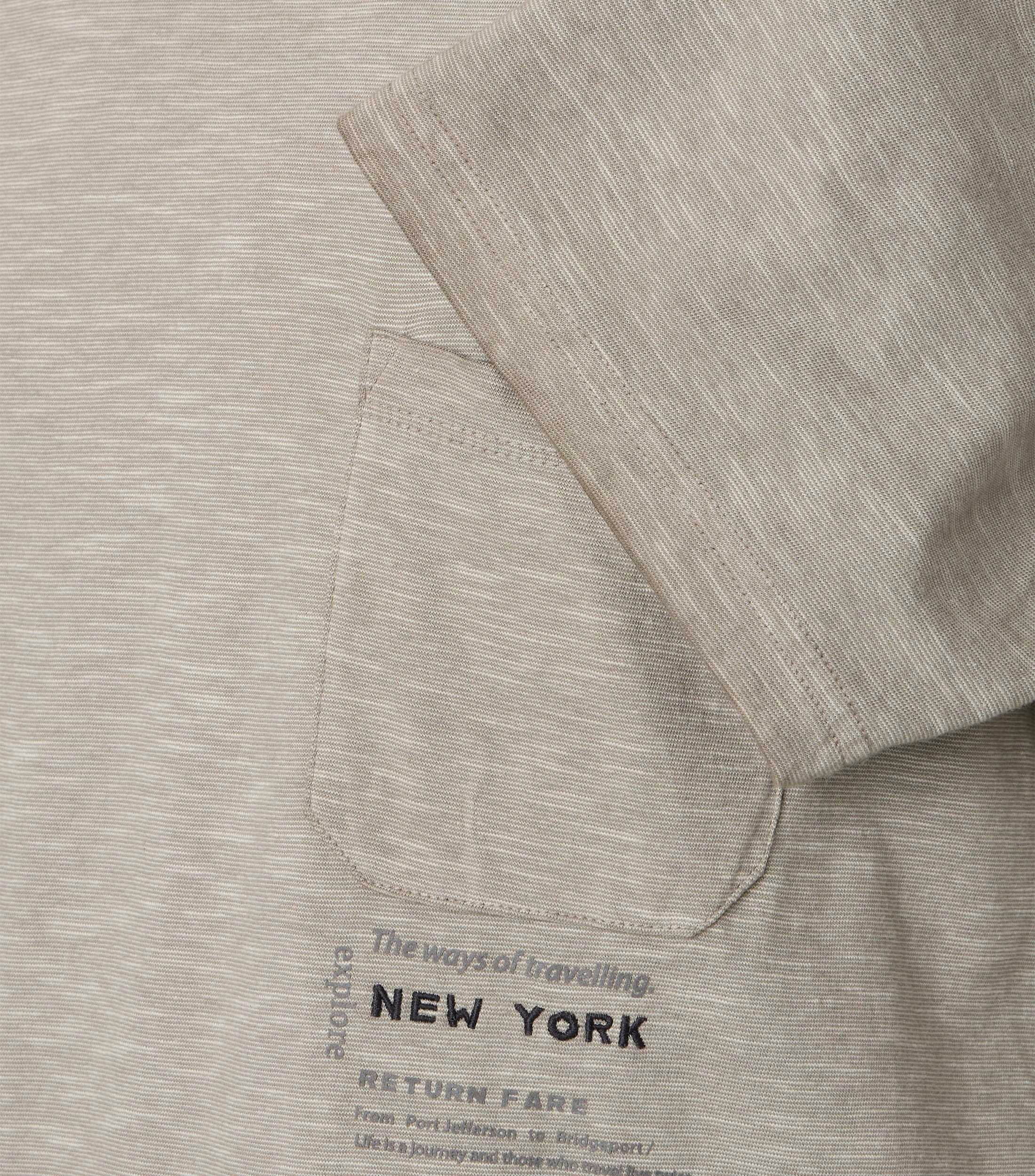 Das Model trägt ein TShirt im uni Muster in der Farbe Beige