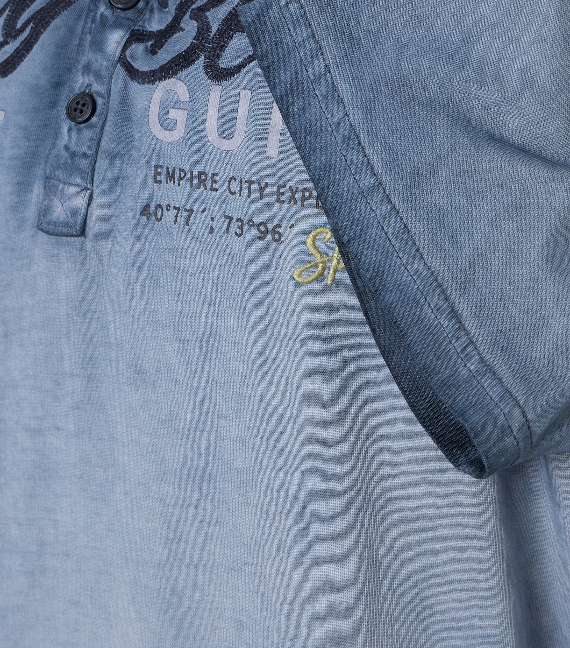 Das Model trägt ein TShirt im uni Muster in der Farbe Blau