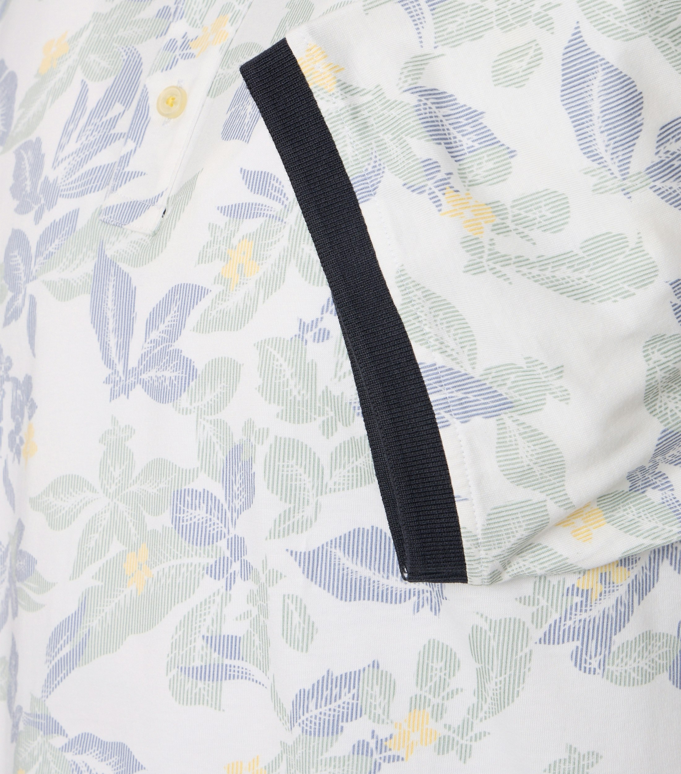 Das Model trägt ein PoloShirt im Print Muster in der Farbe Blau