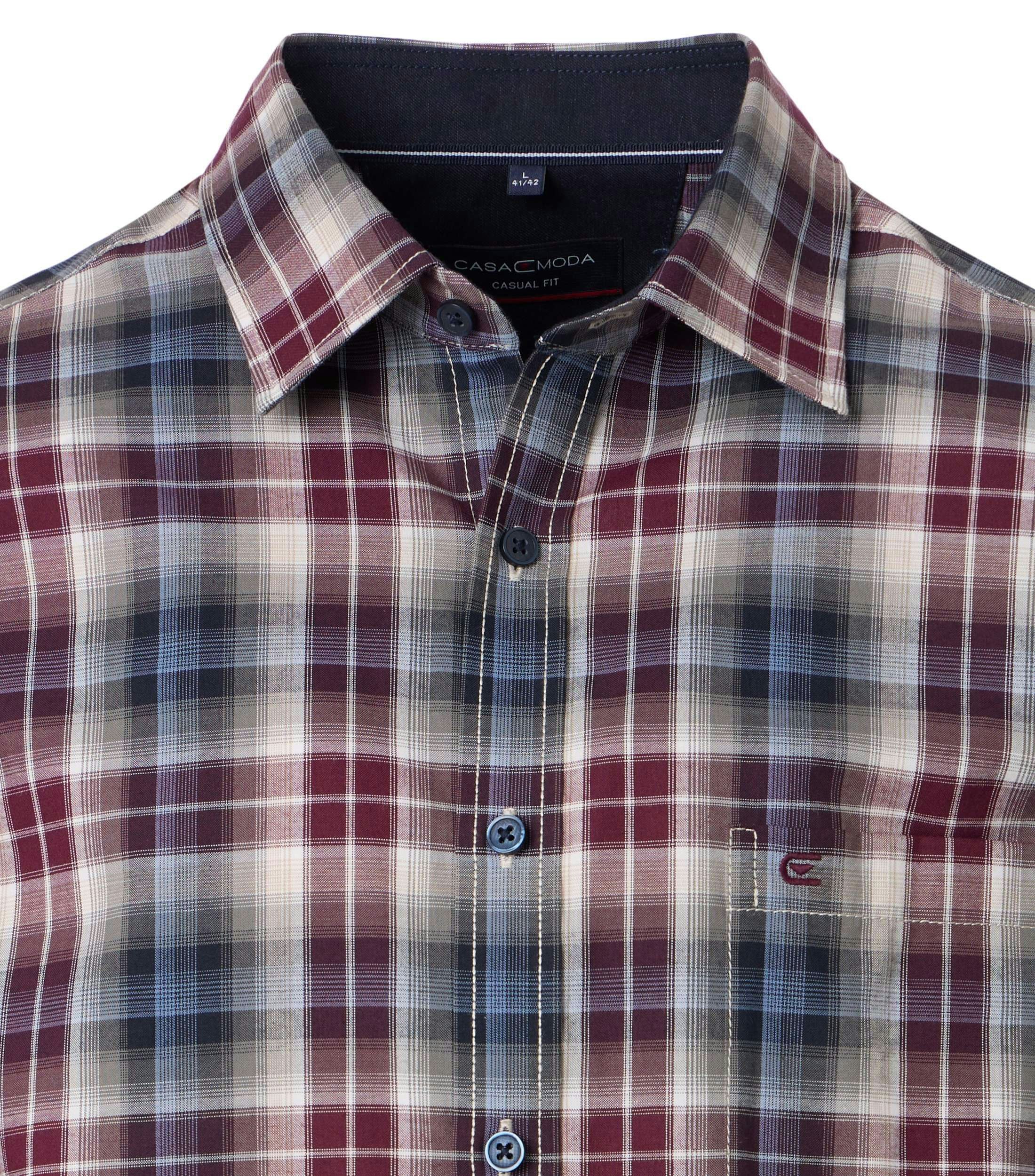 Das Model trägt ein Freizeithemd im kariert Muster in der Farbe Rot