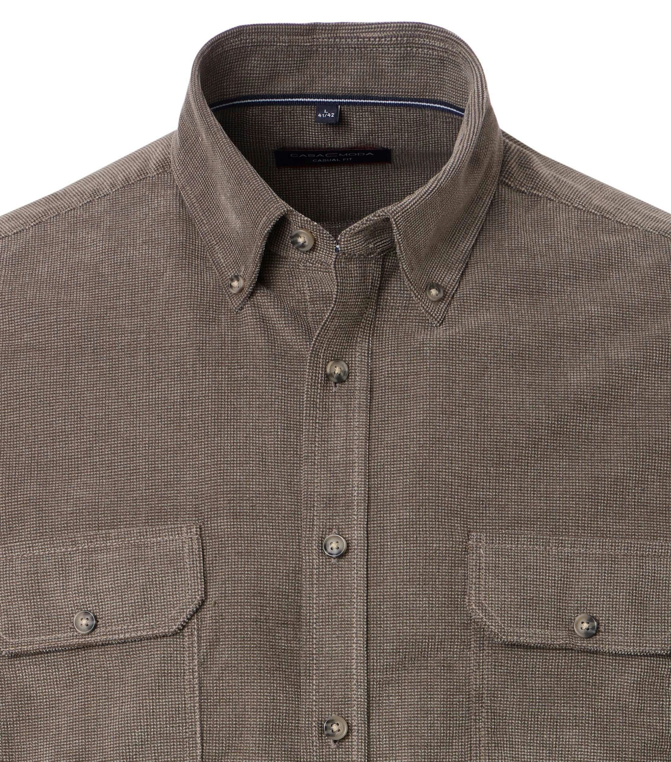 Das Model trägt ein Freizeithemd im uni Muster in der Farbe Beige