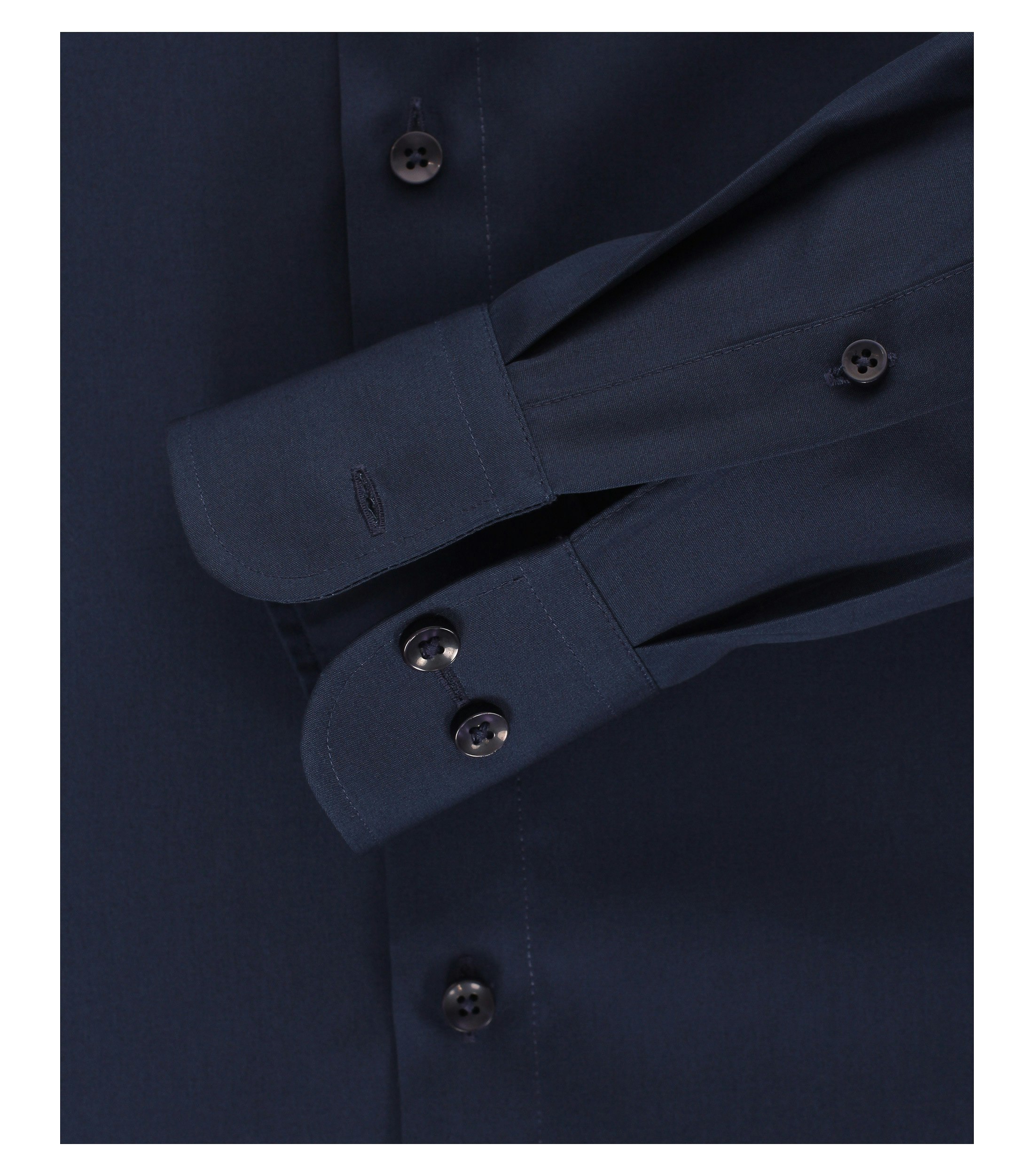 Das Model trägt ein Businesshemd im uni Muster in der Farbe sattes Dunkelblau