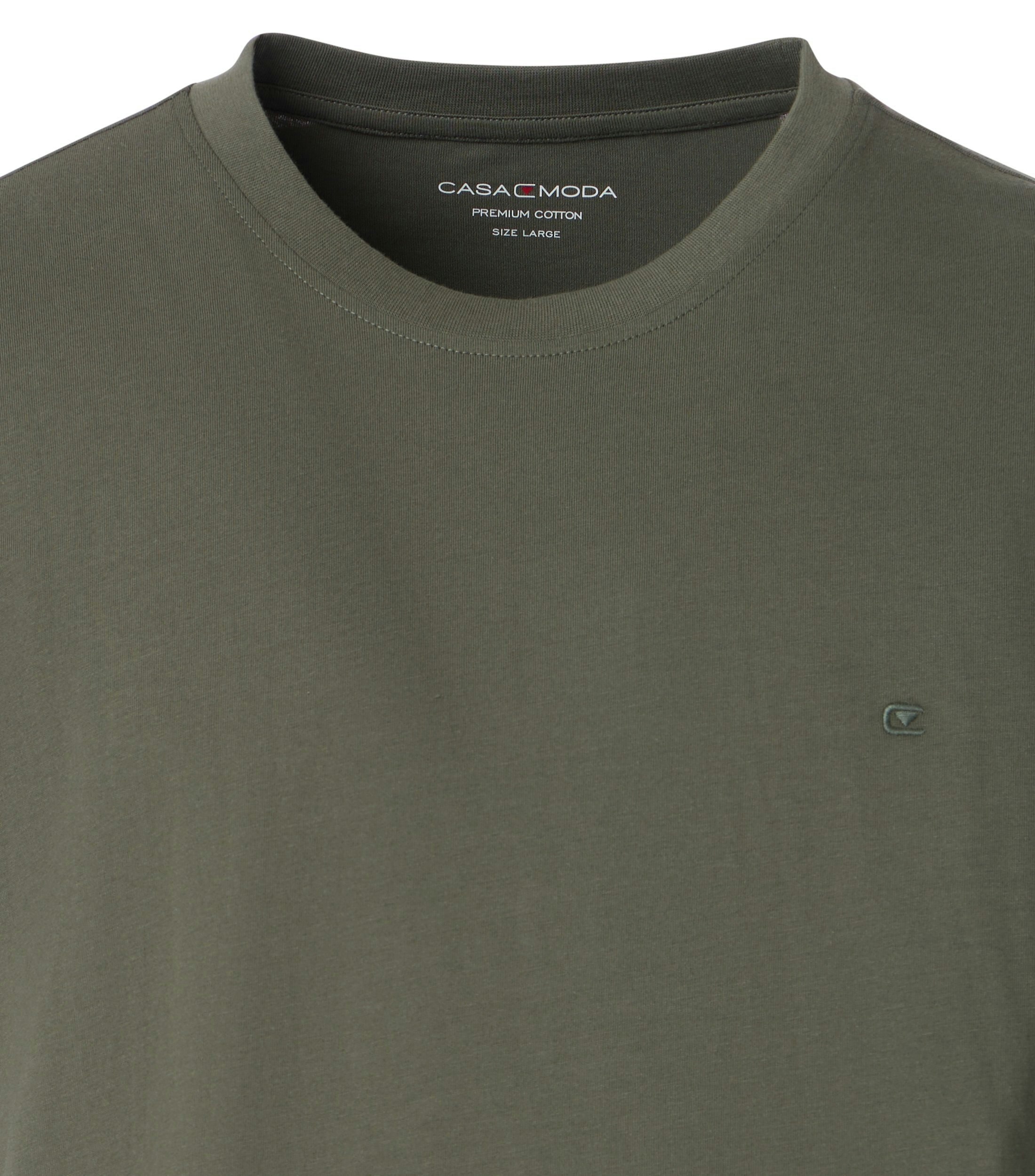 Das Model trägt ein TShirt im uni Muster in der Farbe Olive