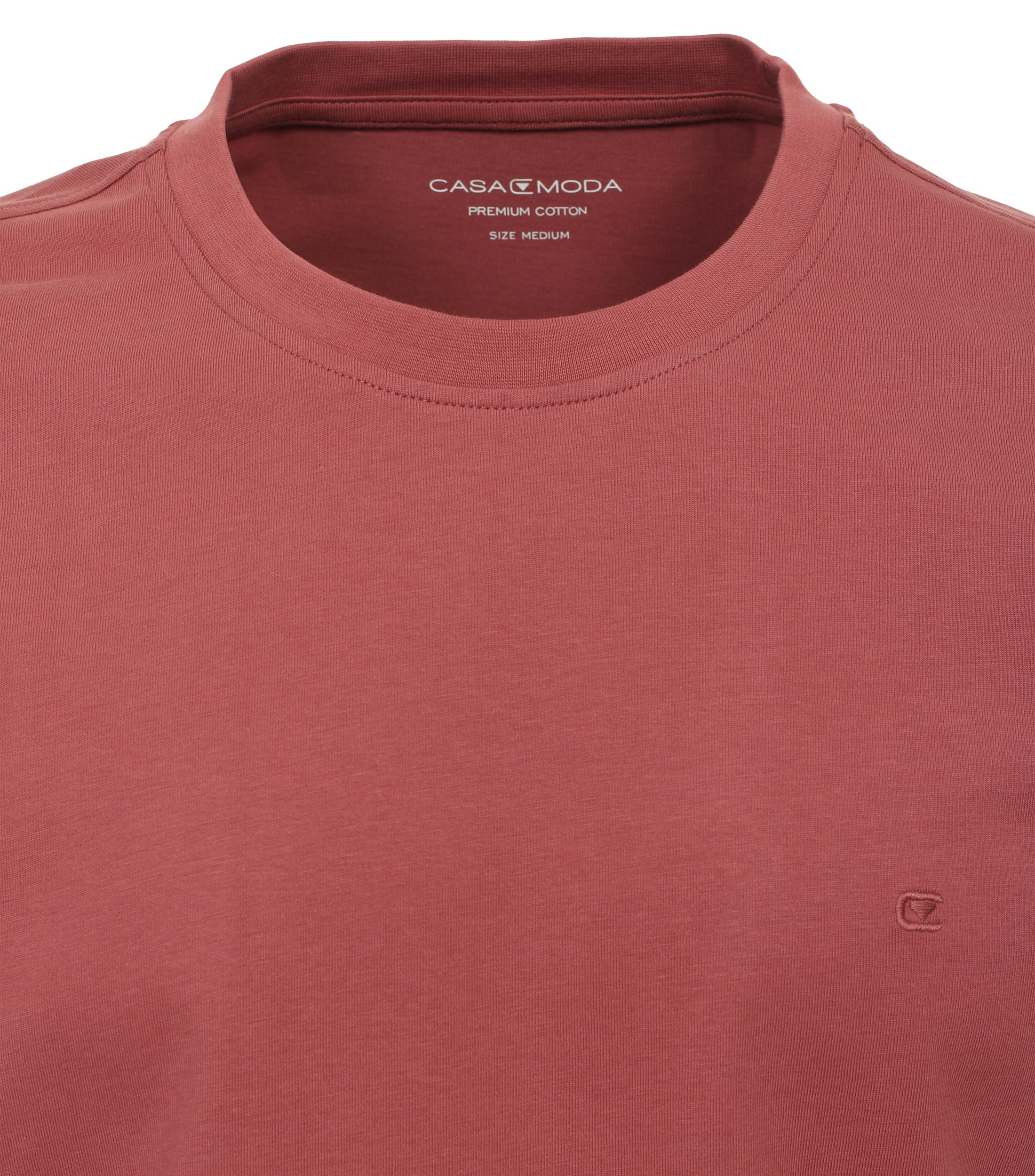 Das Model trägt ein TShirt im uni Muster in der Farbe Hellrot